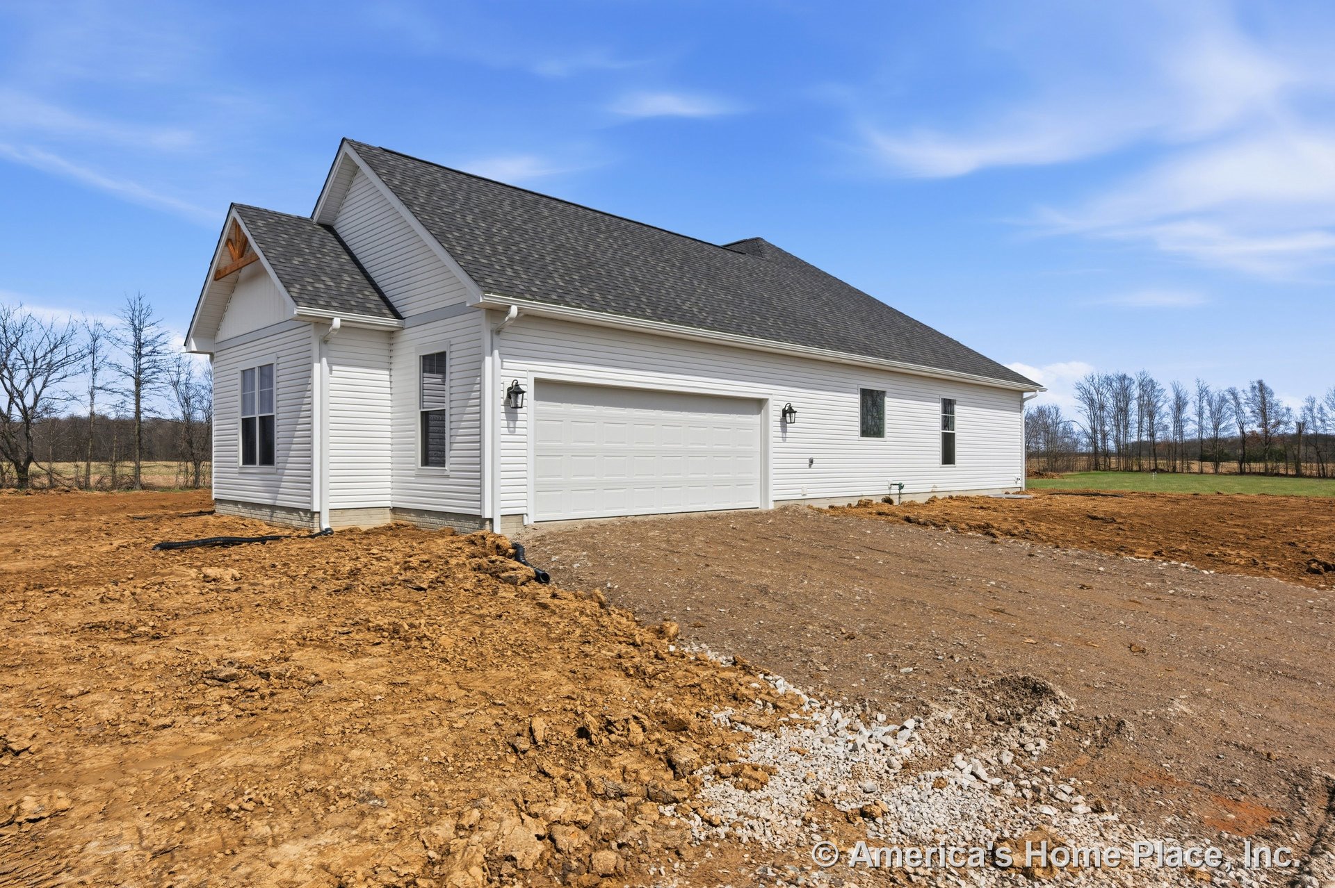 White vinyl siding exterior with gable roof clad in asphalt shingles, two-car garage featuring paneled doors, double-hung windows, wall-mounted exterior lighting, and unfinished