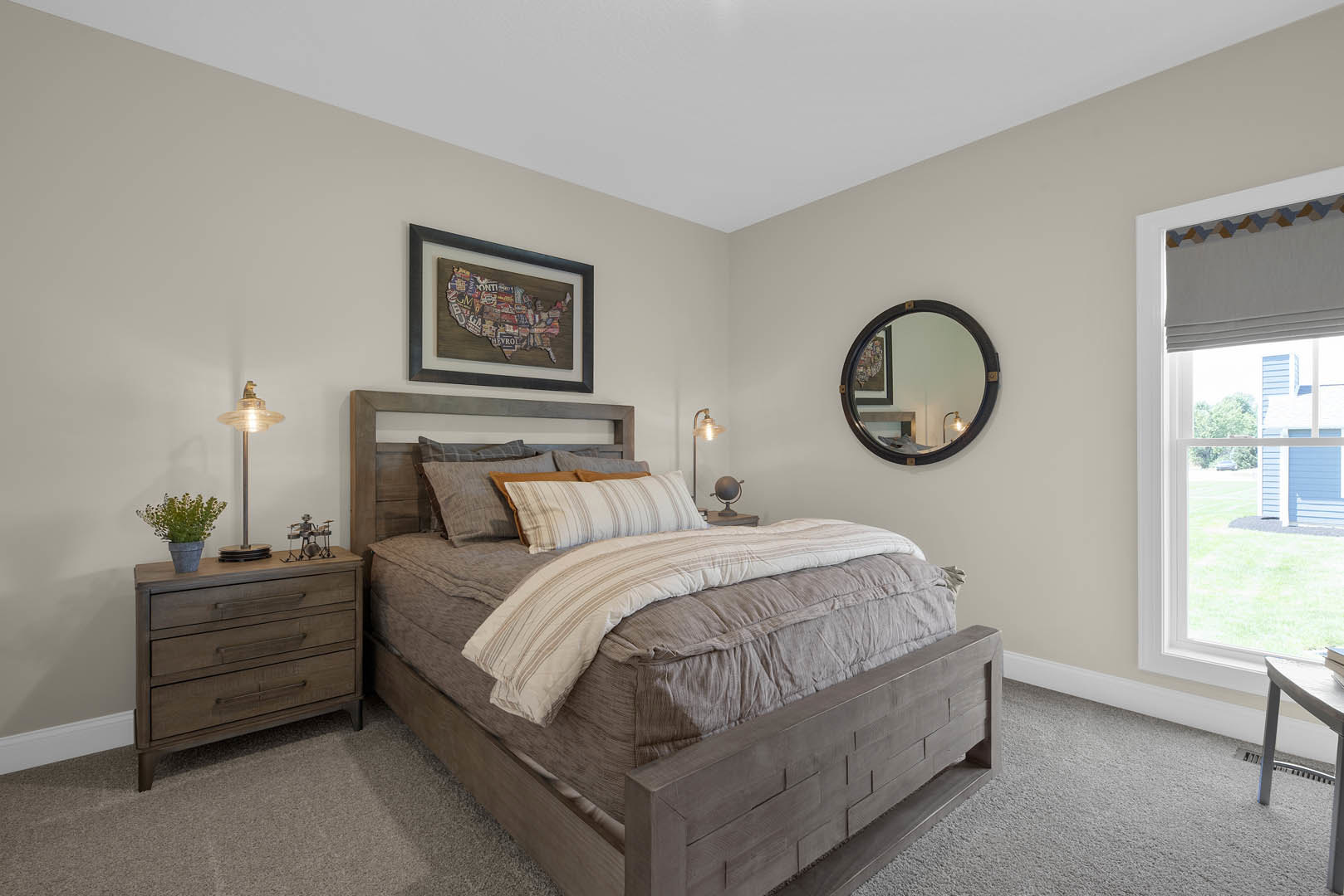 Bedroom with wooden headboard bed, white bedding, wall-mounted mirror, nightstand with lamp, dresser topped with planter, and decorative pillows