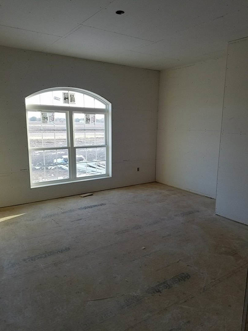 Concrete floor and plaster walls in a bright room with large window overlooking snowy landscape