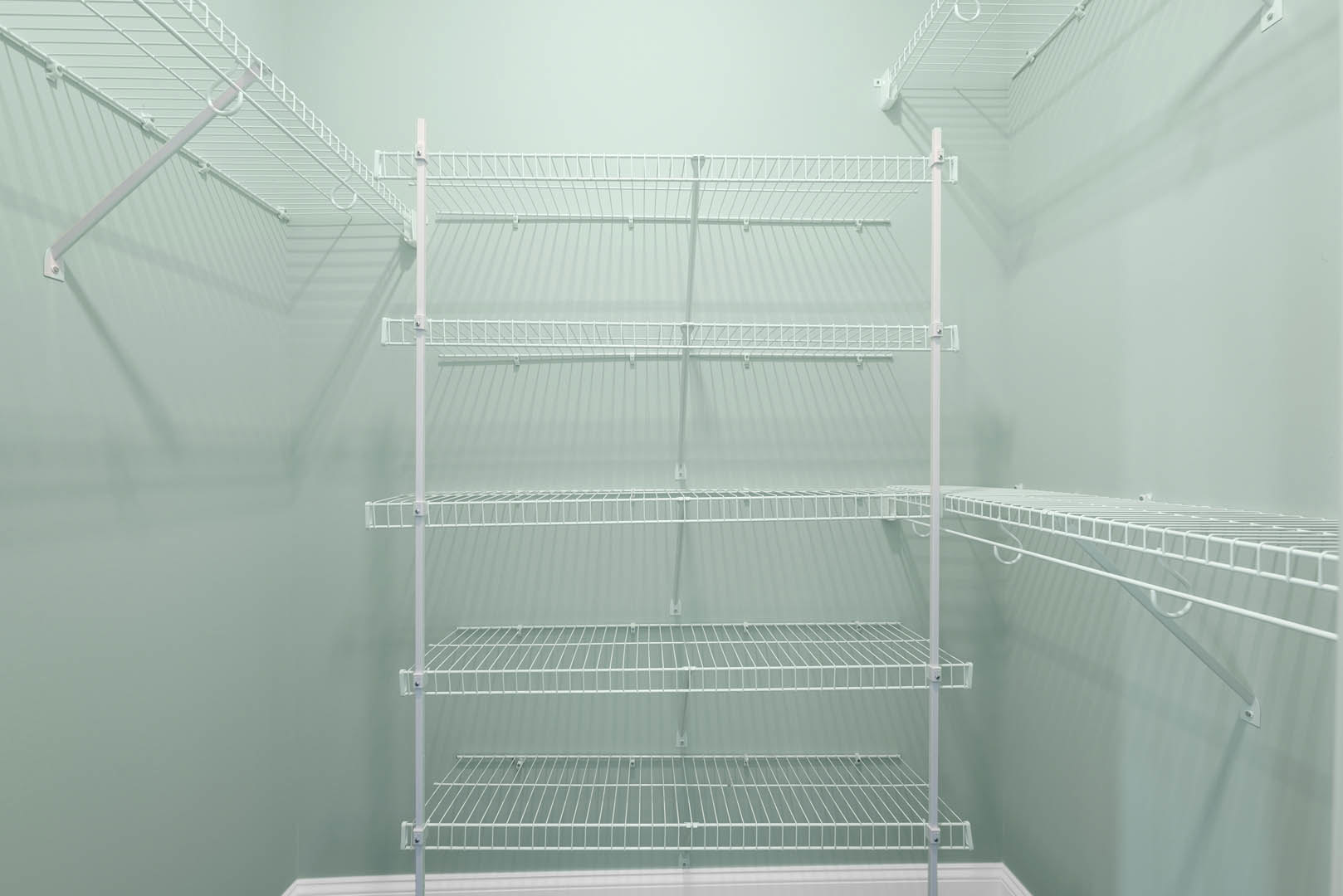 White wire shelving mounted on a white wall in a small indoor room