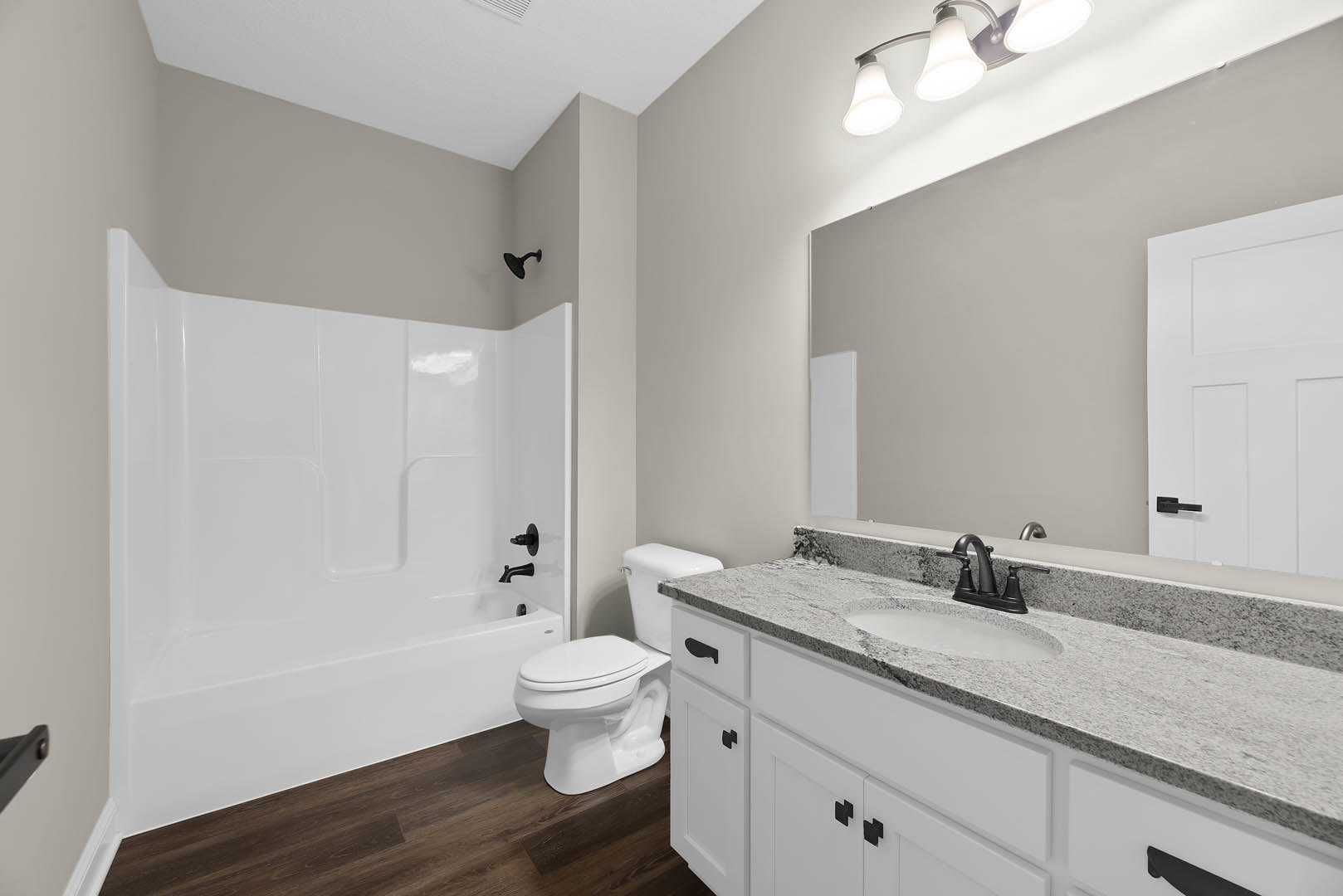 Modern bathroom with white ceramic sink, matching toilet, light gray tile flooring, white cabinetry, chrome faucet, and neutral wall paint