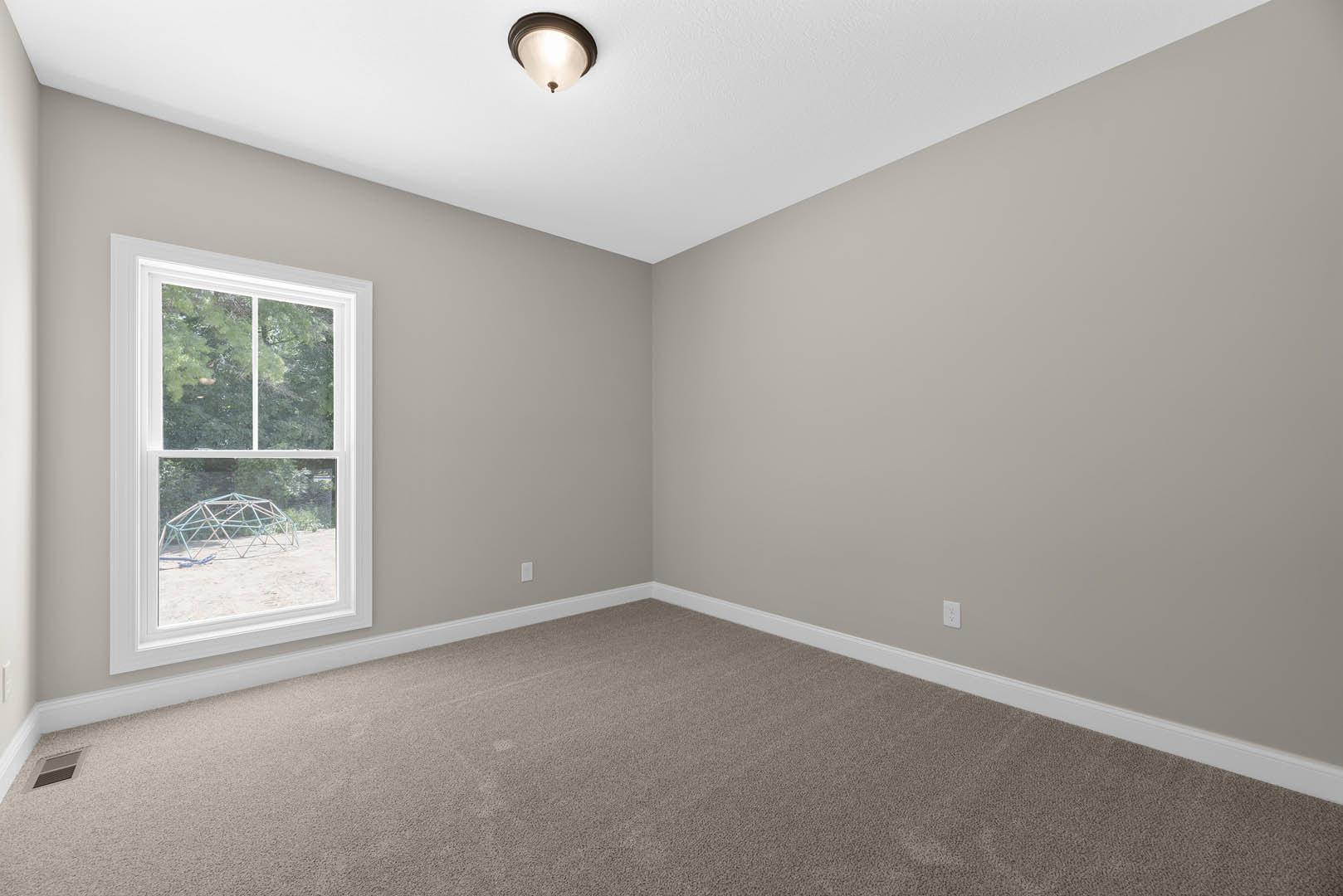 Carpeted room with white walls, large window overlooking exterior structure, metal light fixture, wall vent, and decorative molding