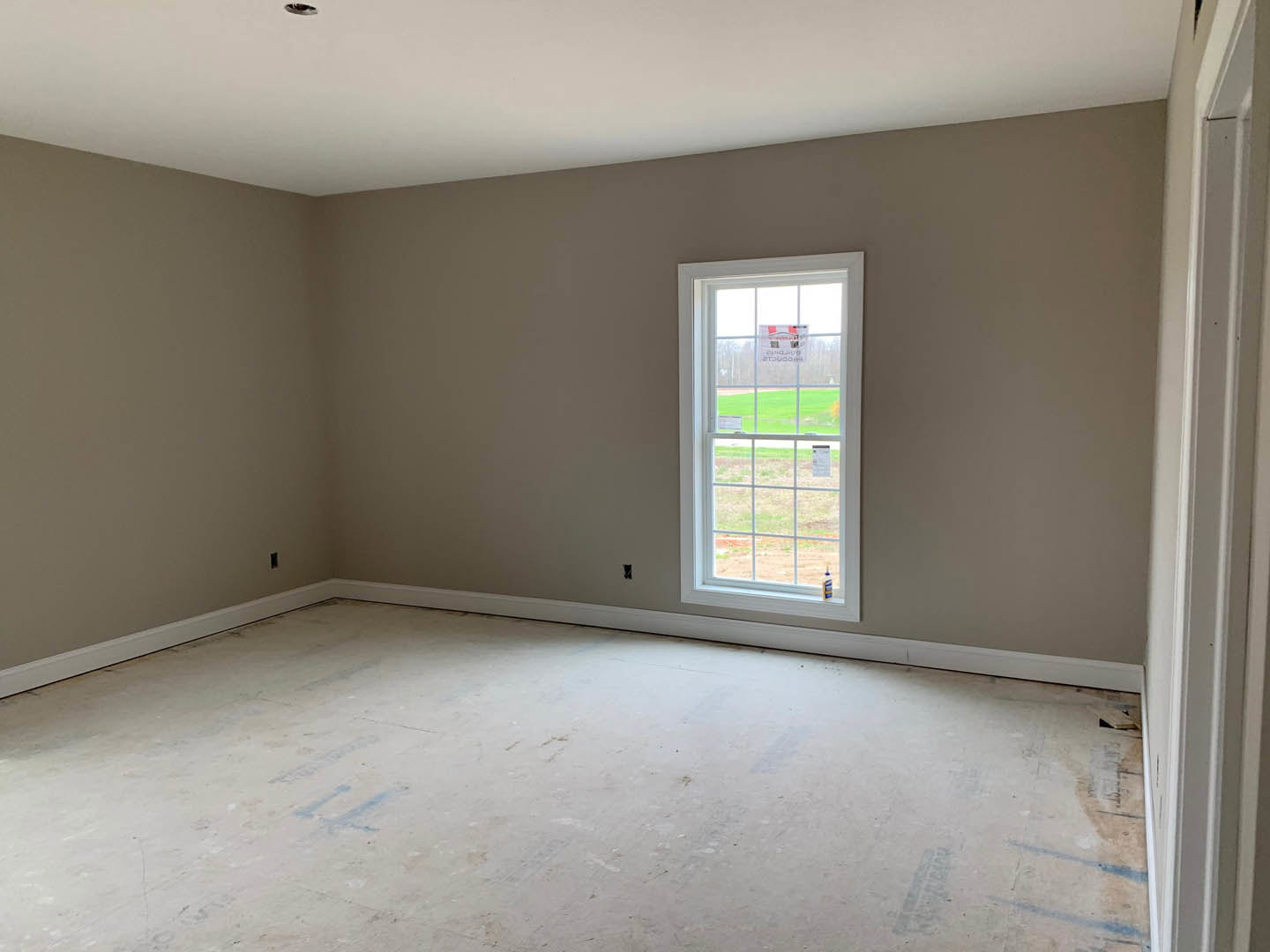 Bright room with two large windows, white plaster walls, light flooring, and contrasting black and white ceiling fixtures