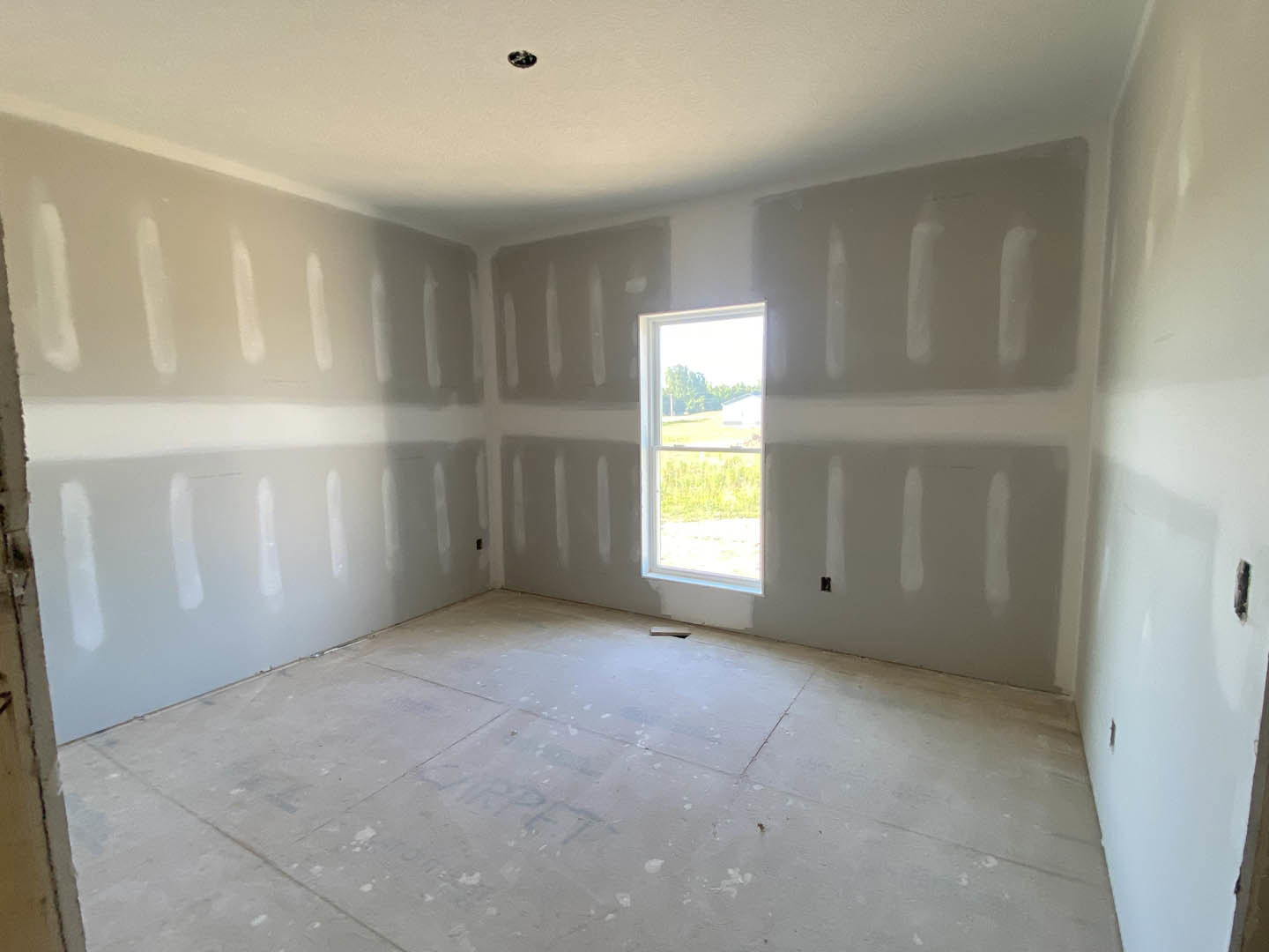 White-painted room with a large window, tile flooring, and black trim along the wall