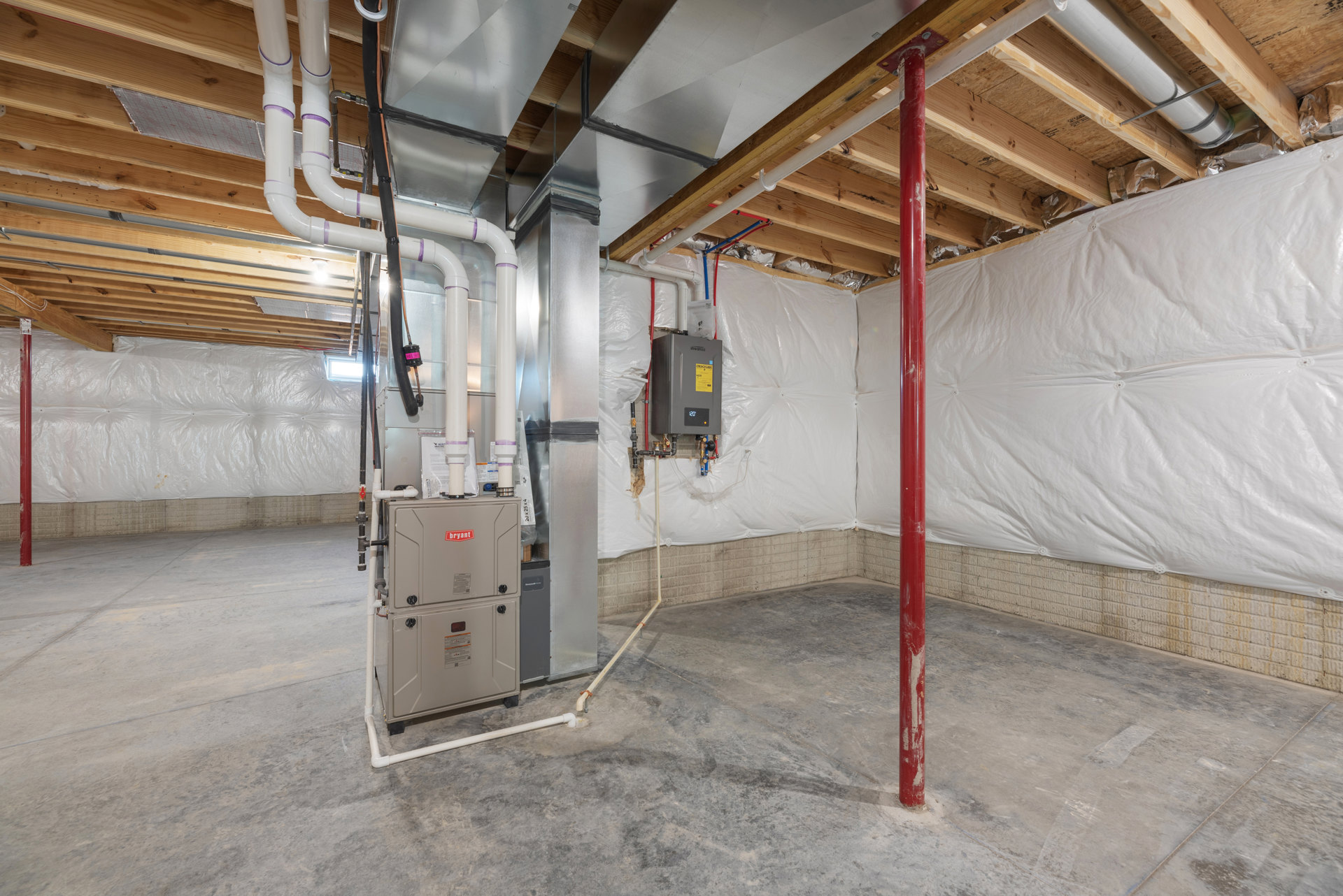 Basement utility room with exposed steel and aluminum pipes, white insulated walls, metal vent on ceiling, and mechanical equipment.
