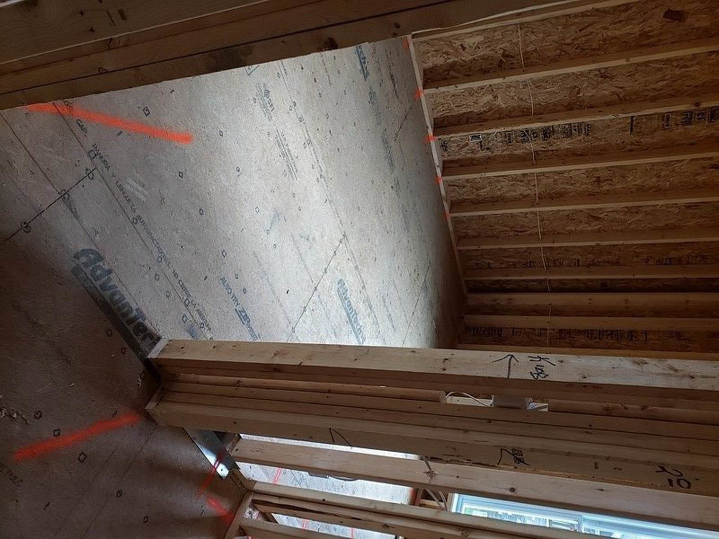 Exposed wood ceiling beams above plaster walls, large window with natural light, neutral finishes throughout indoor living space