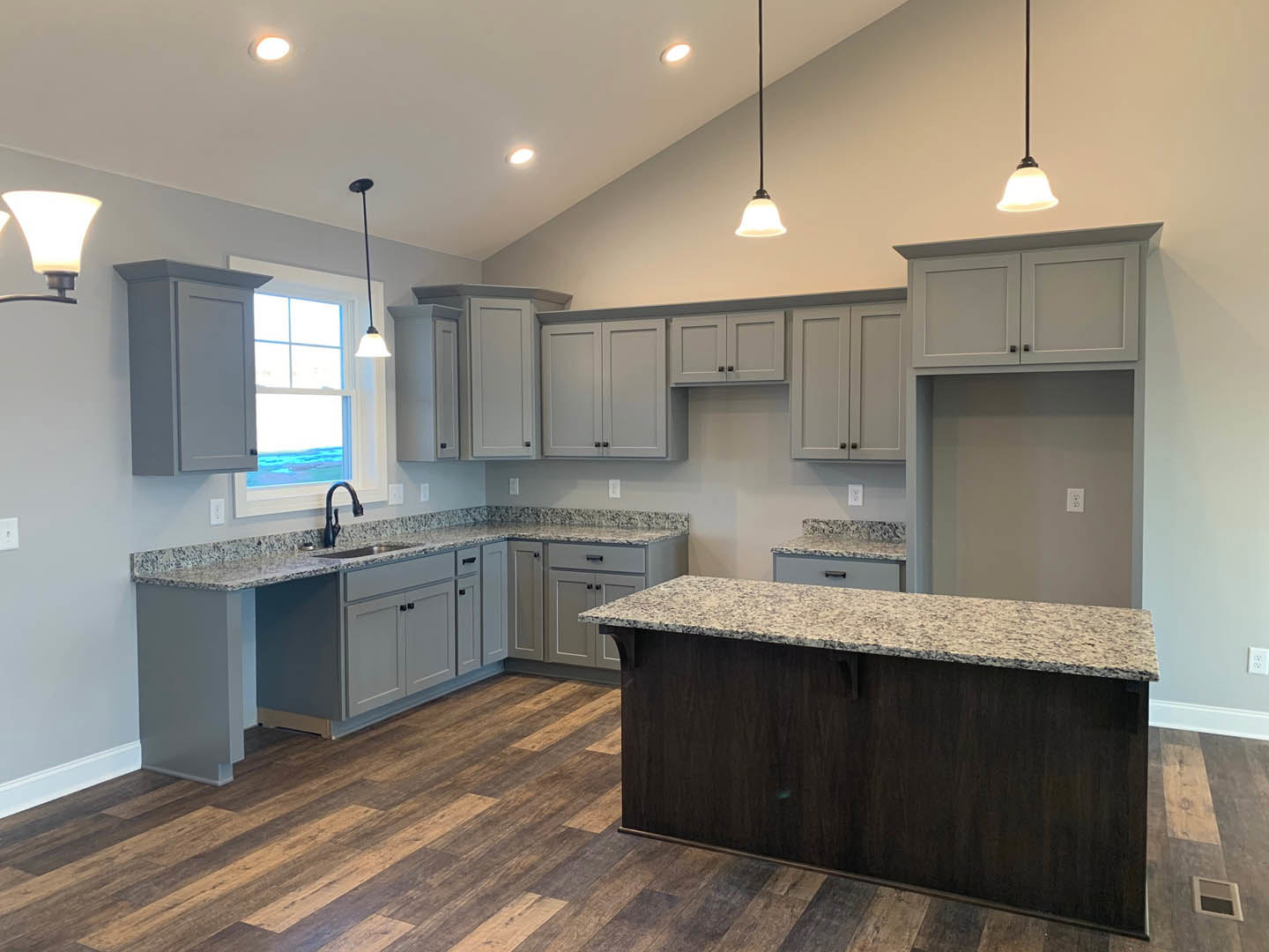 Kitchen with granite countertops, wood flooring, white cabinetry, black curved faucet, and tile backsplash