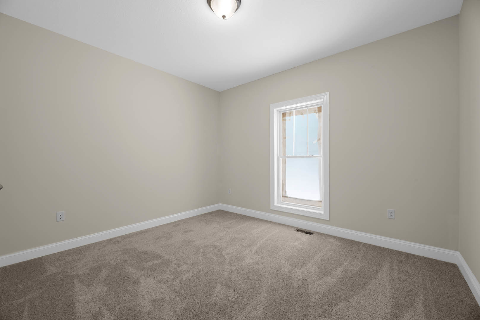 Bedroom with beige carpet, white walls, large window with white trim, ceiling-mounted light fixture, and crown molding.