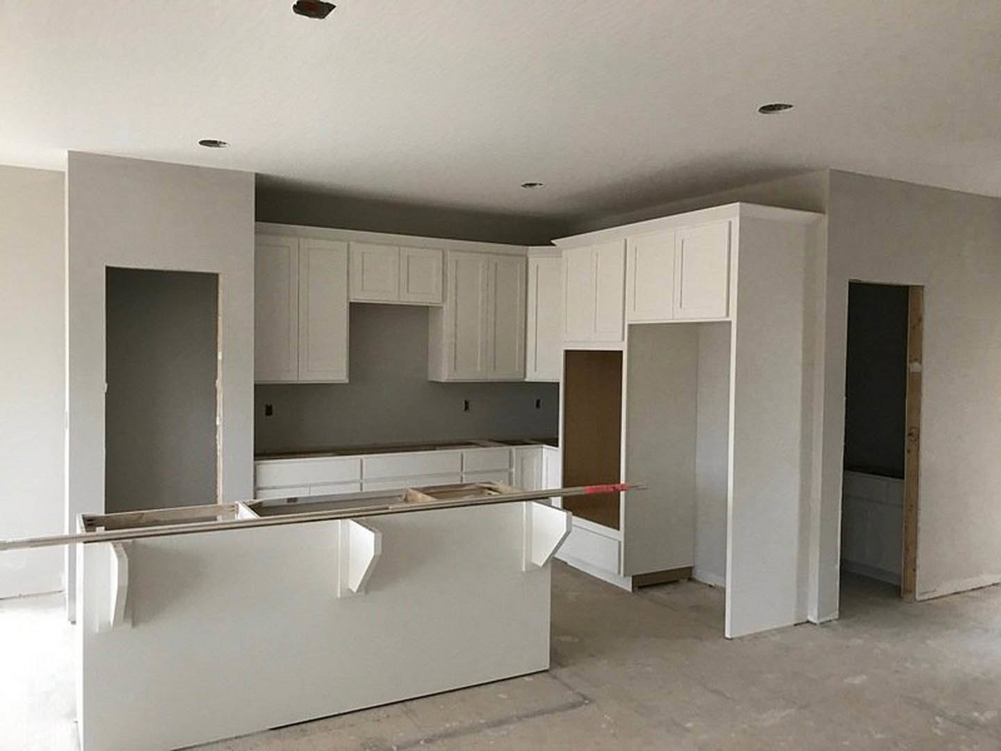 White kitchen with shaker cabinets, quartz countertops, stainless steel sink, and modern hardware