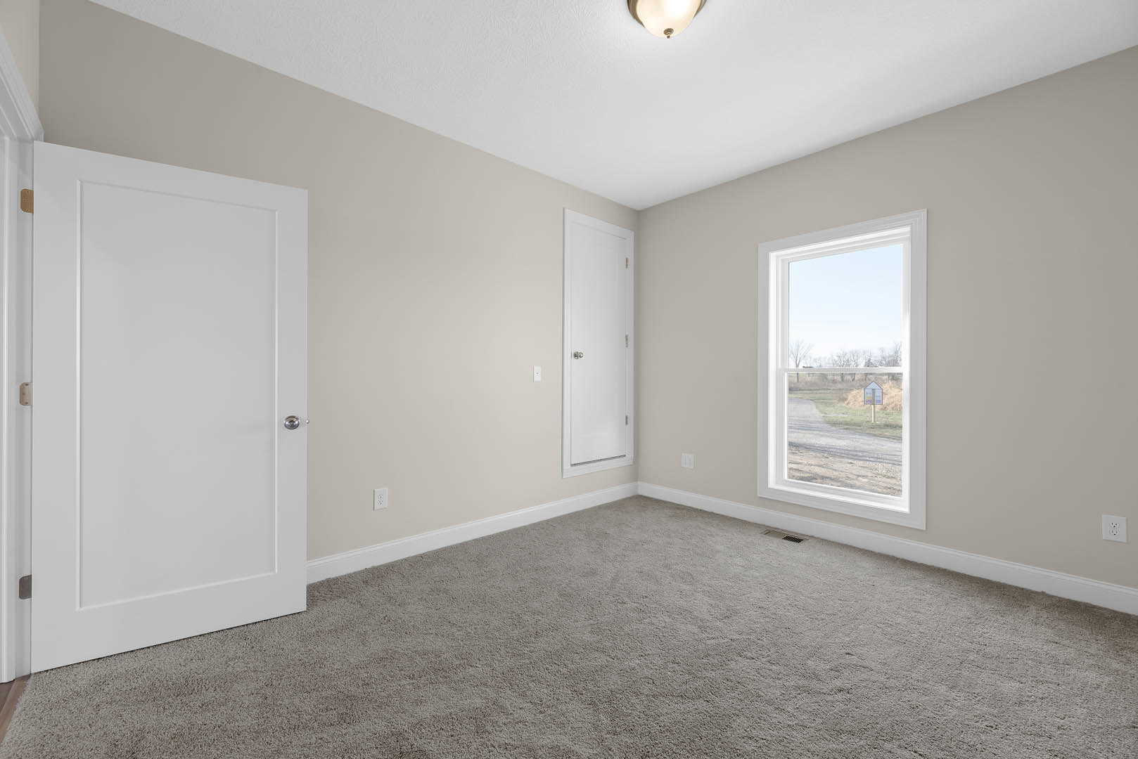 White paneled door with silver knob, window featuring a posted sign, beige carpet flooring, white plaster walls, ceiling light fixture, decorative molding along baseboards.