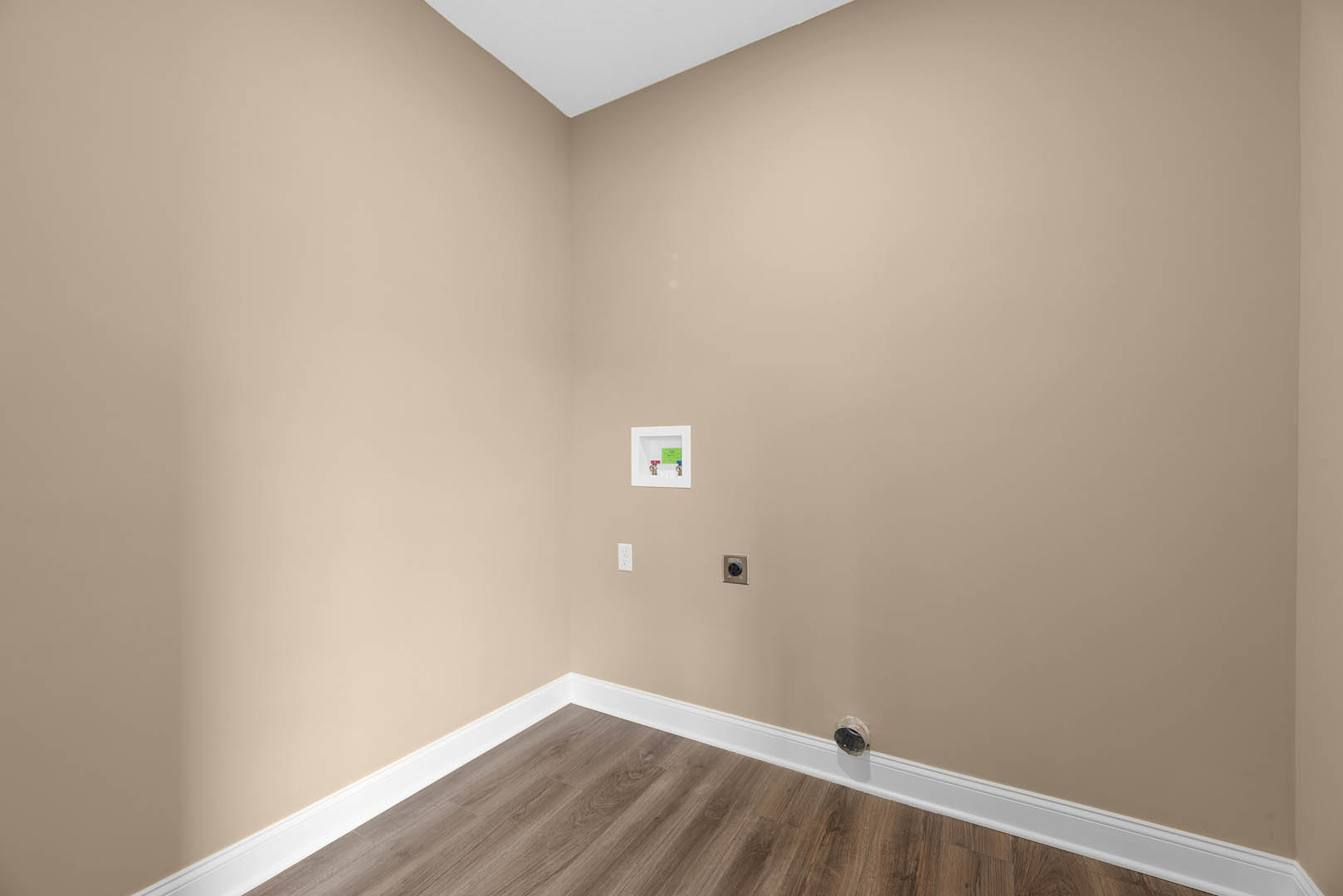 Wood floor with white baseboards, white plaster ceiling, recessed lighting, and smooth white walls in a residential interior.