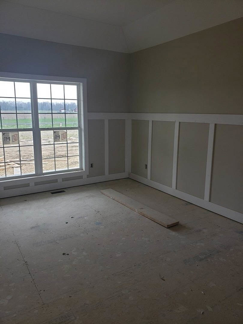 White-walled room with multi-pane window, wood plank flooring, white trim, and metal strip detail