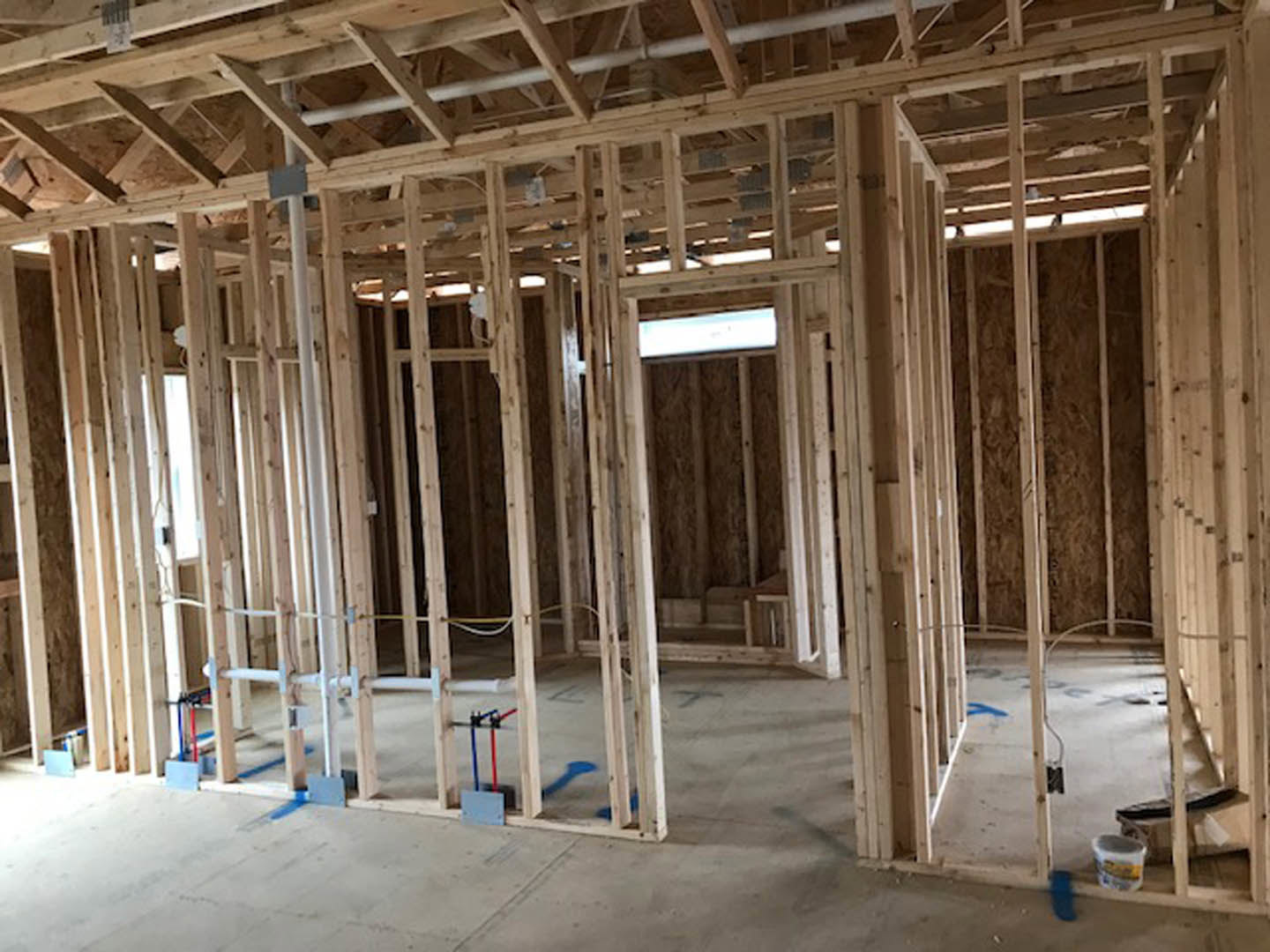 Unfinished room with exposed wood framing, ceiling beams, and visible insulation