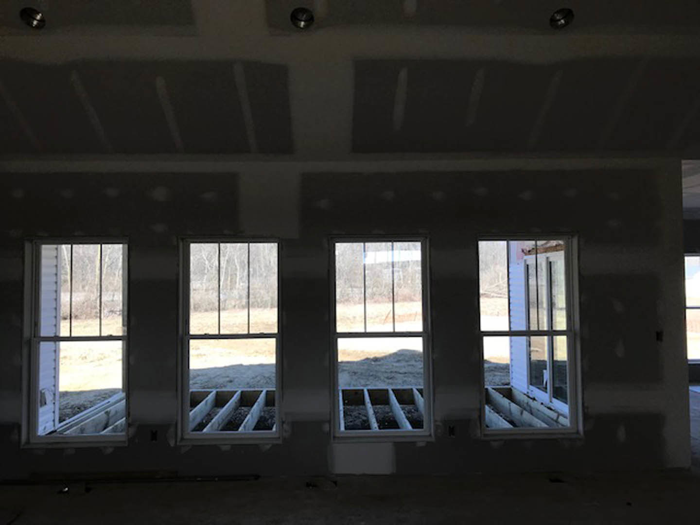 Sunlit room featuring large windows, white walls, and smooth ceiling with recessed lighting fixtures