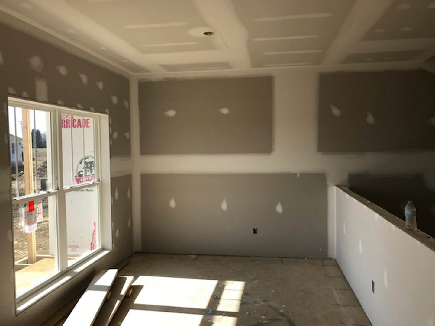 Bright room with smooth white walls, large window with clear glass, light-colored ceiling, and minimalist finishes