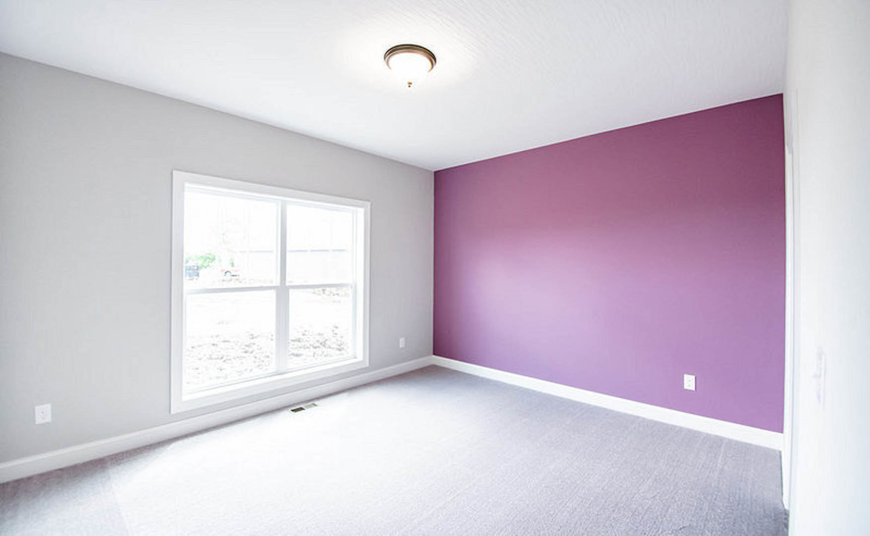 Purple-painted walls, white-framed window, white carpet flooring, white electrical outlet on wall