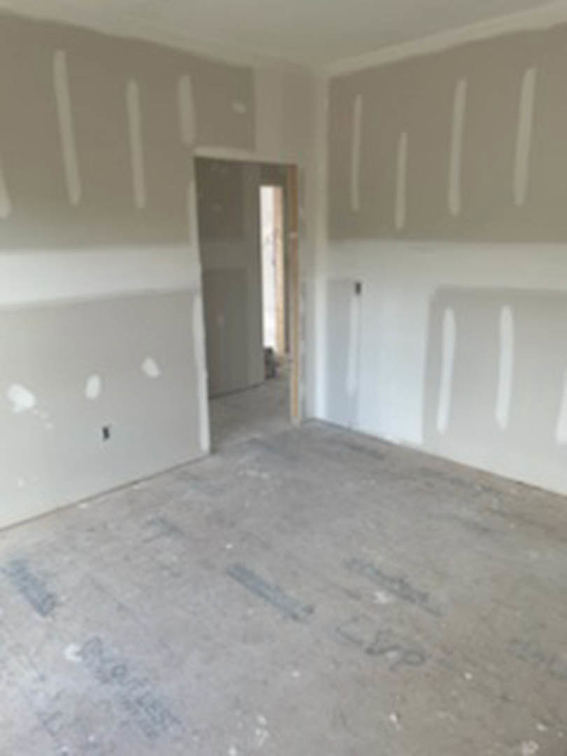White walls, tile flooring, white door, and built-in white shelf in a remodeled interior room