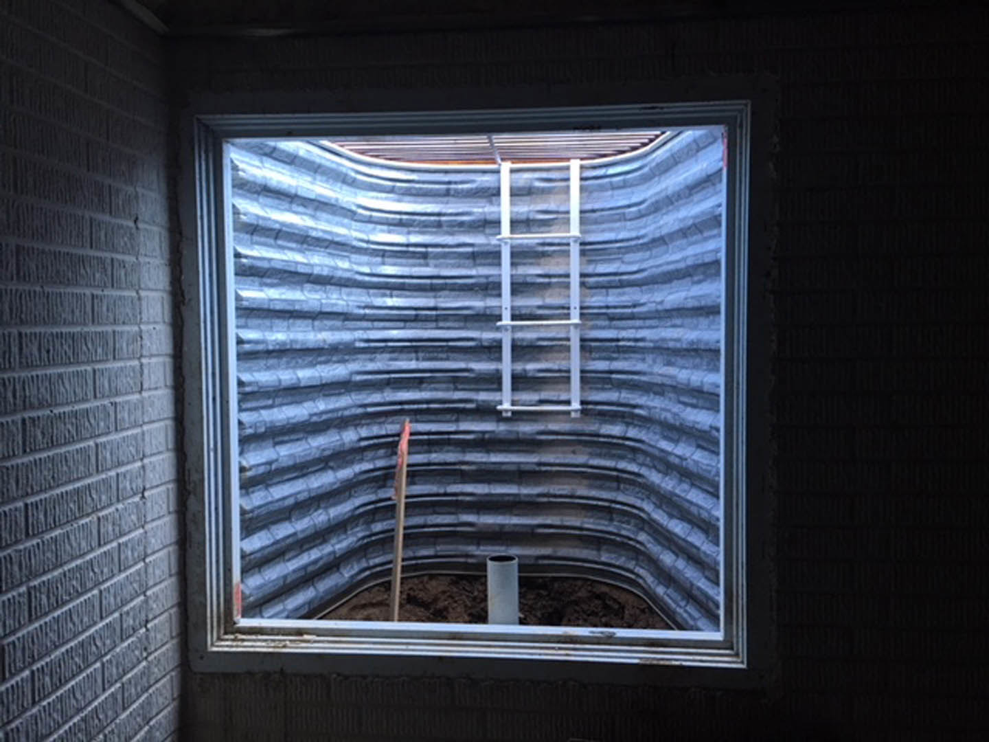 Large window with white blinds, wooden ladder leaning inside, bright natural daylight, symmetrical interior wall