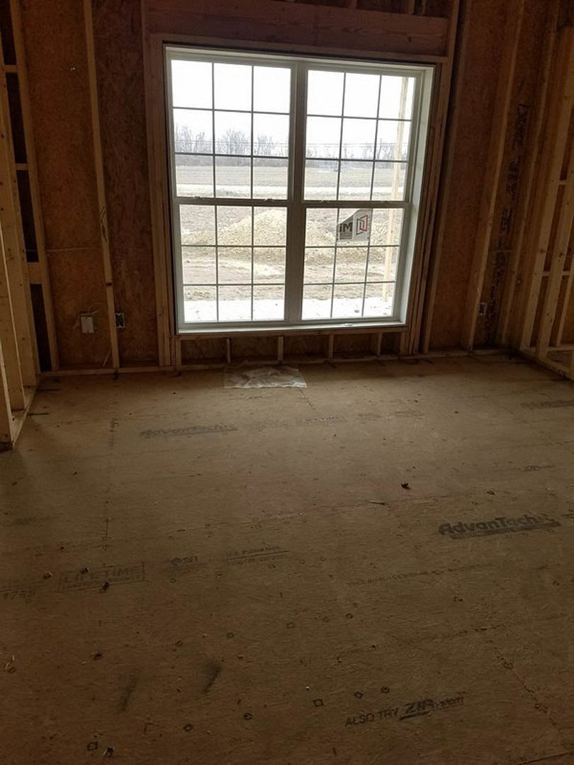 Large window with white trim set in a room featuring light wood plank flooring and neutral walls, natural daylight streaming in.
