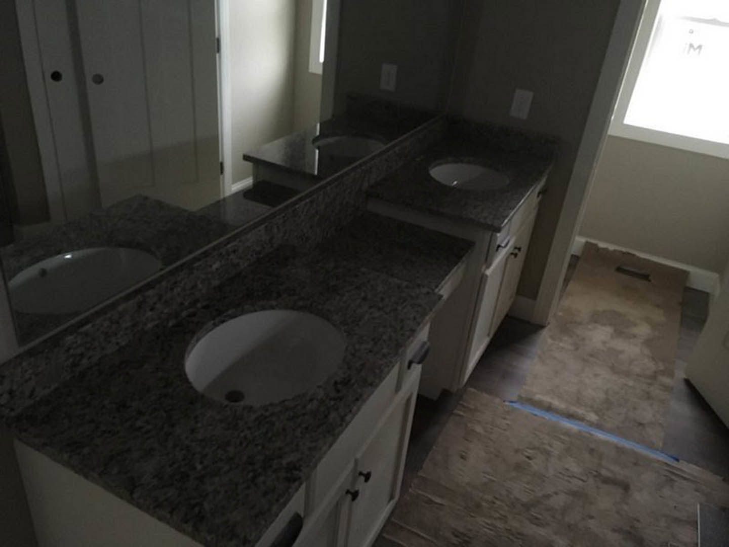 Bathroom featuring marble countertops, undermount sink, chrome faucet, white cabinetry, and tiled walls