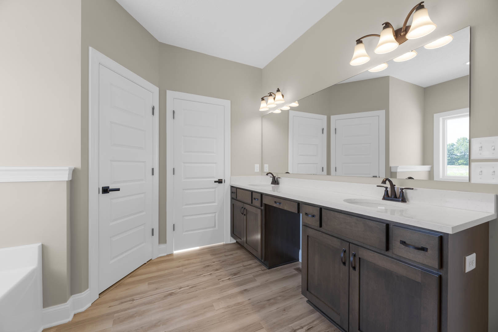 Bathroom with double vanity, white shaker doors, black hardware, tile flooring, quartz countertop, modern light fixture, and wall outlet