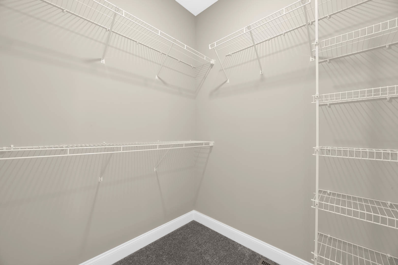 Bathroom with white built-in shelves, plaster walls, metal rod, and carpeted floor near a window