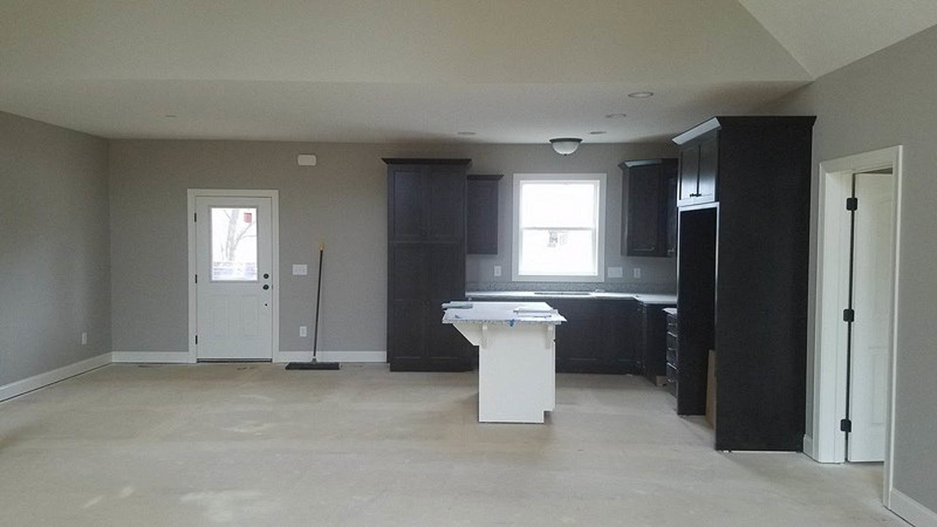 Kitchen with matte black cabinets, white quartz countertop, stainless steel appliances, light tile backsplash, and recessed lighting.