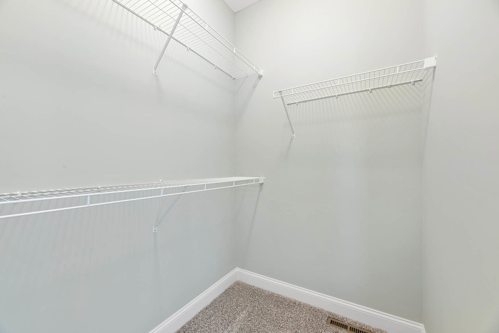 White built-in shelves on a plaster wall, marble tile flooring, and recessed ceiling in a modern bathroom.