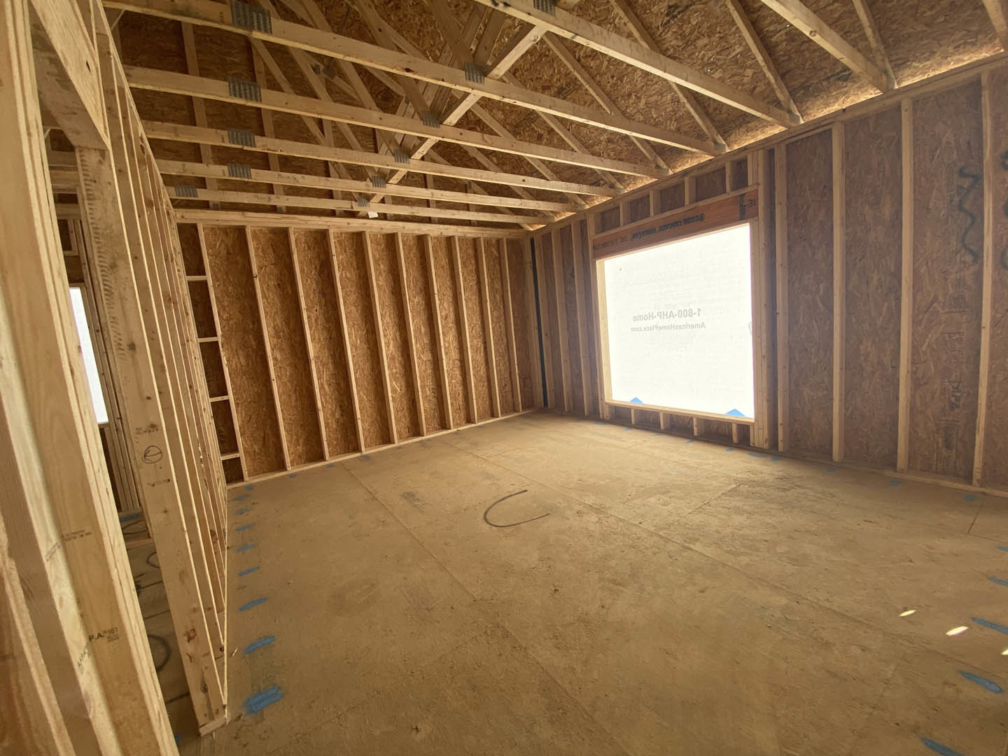 Skylight window set in wooden plank ceiling above concrete floor, with exposed beams and neutral walls.