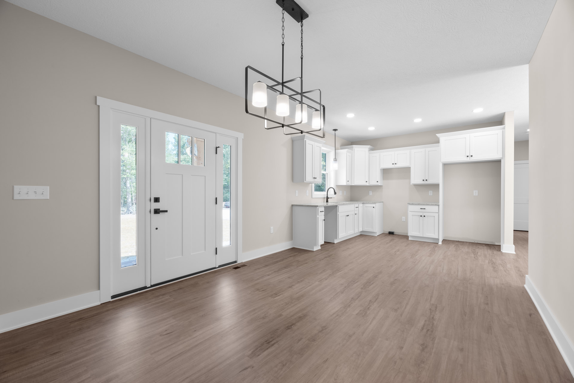 White cabinets with marble countertops, wood flooring, white walls, glass-paneled door, ceiling light fixture, and white light switch