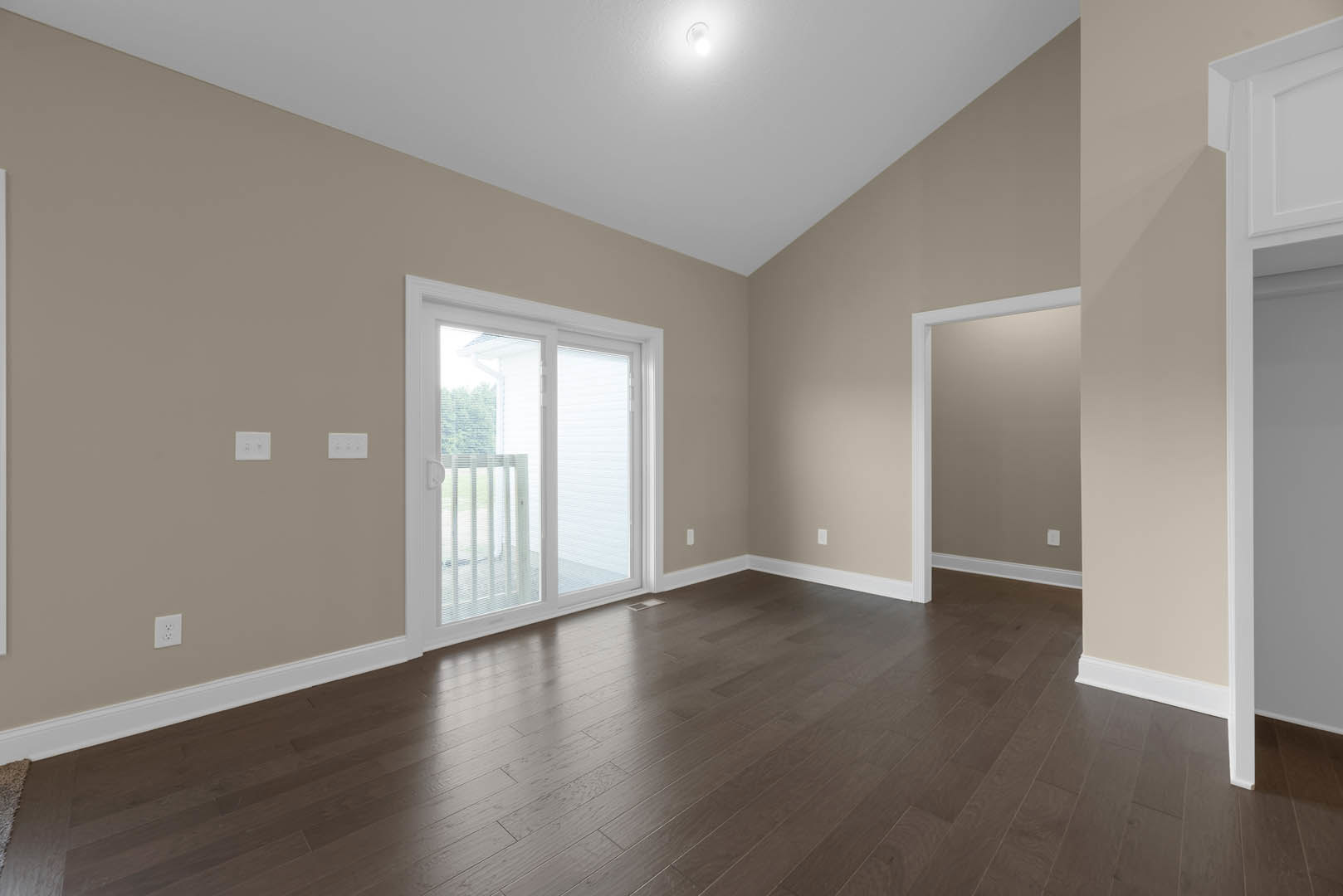 Hardwood floor room with white door and sliding glass door, white door frame, ceiling light, and close-up window