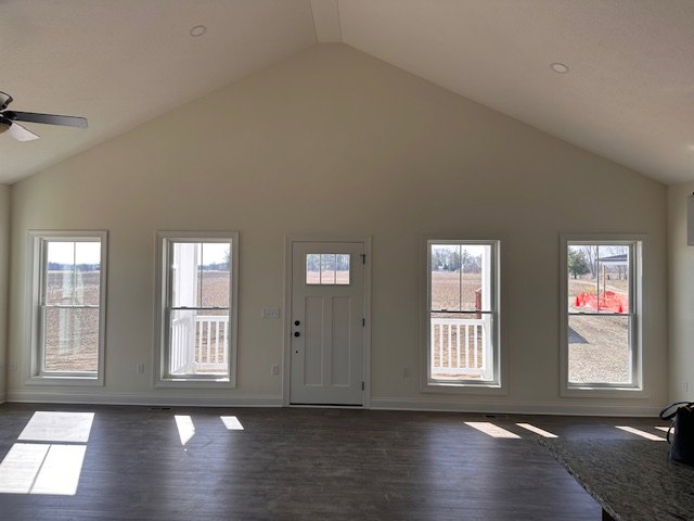 Bright room with light wood flooring, white walls, large windows, and a glass-paneled door