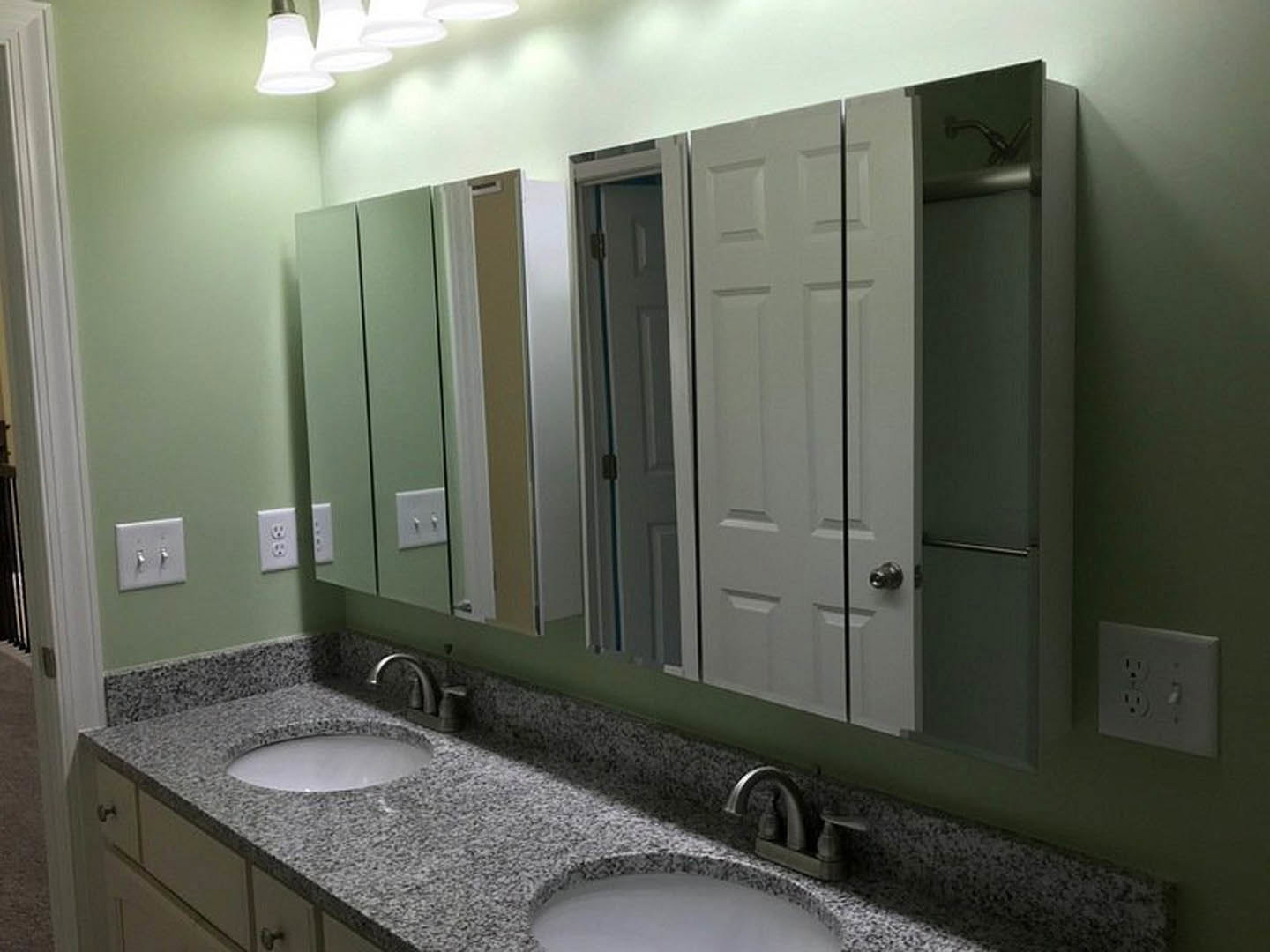 Double vanity with undermount sinks, quartz countertop, framed mirrors, chrome faucets, white tile backsplash, and recessed lighting in a modern bathroom.