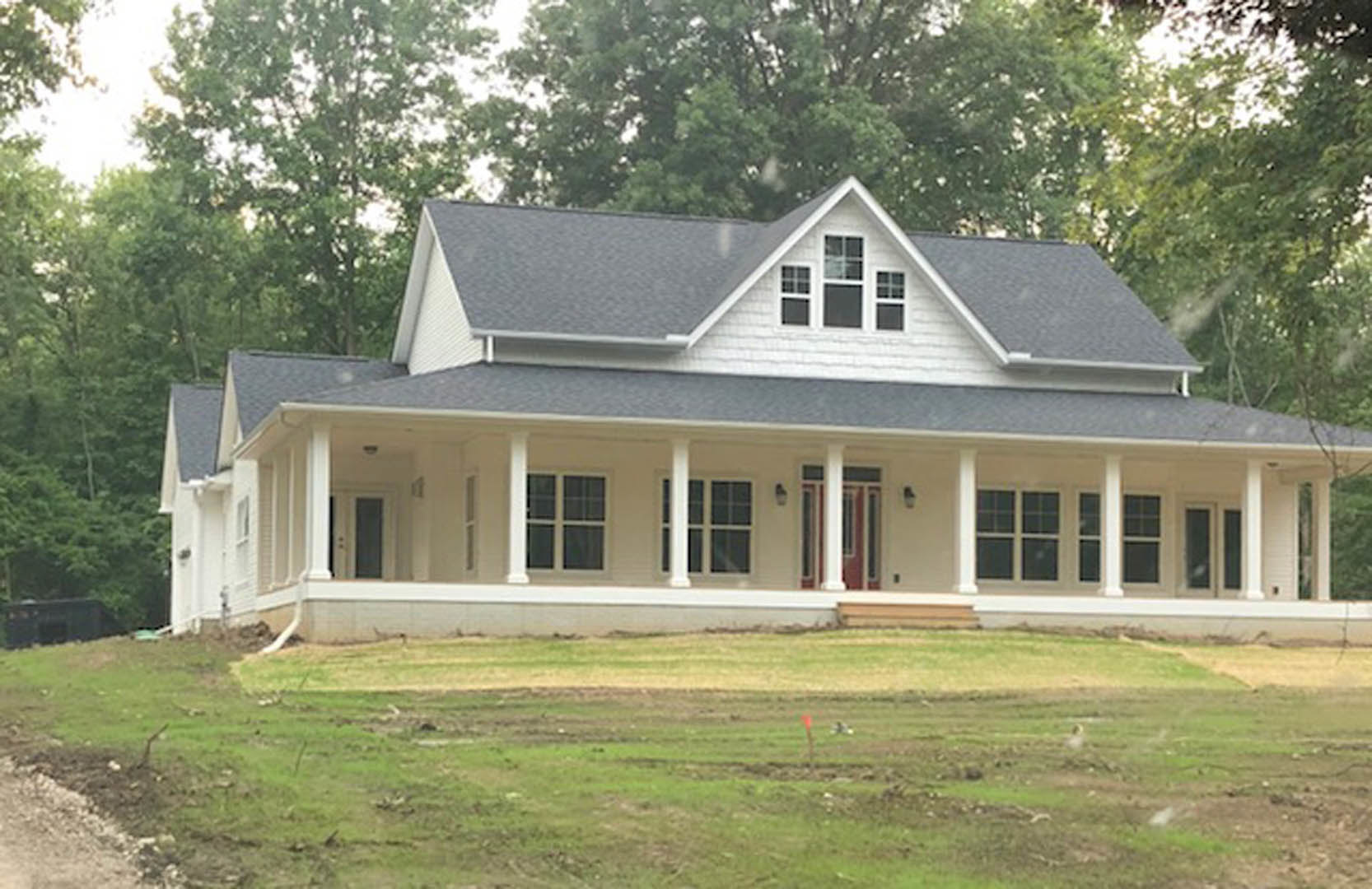 Large white house with spacious porch, white framed windows, grassy lawn, white pillars, and Sidney Lanier Cottage visible in the background.