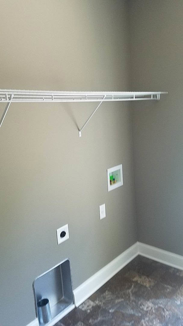 White plaster bathroom wall with a built-in white shelf holding a metal container and tube.