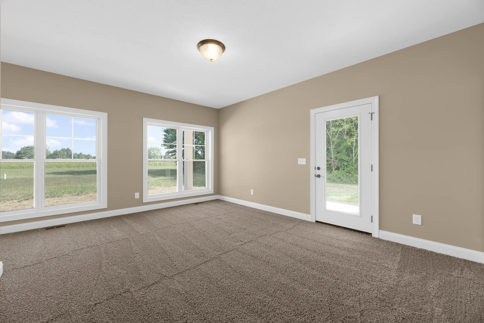 Beige-walled room with white doors, carpeted floor, ceiling light fixture, window overlooking trees and open field