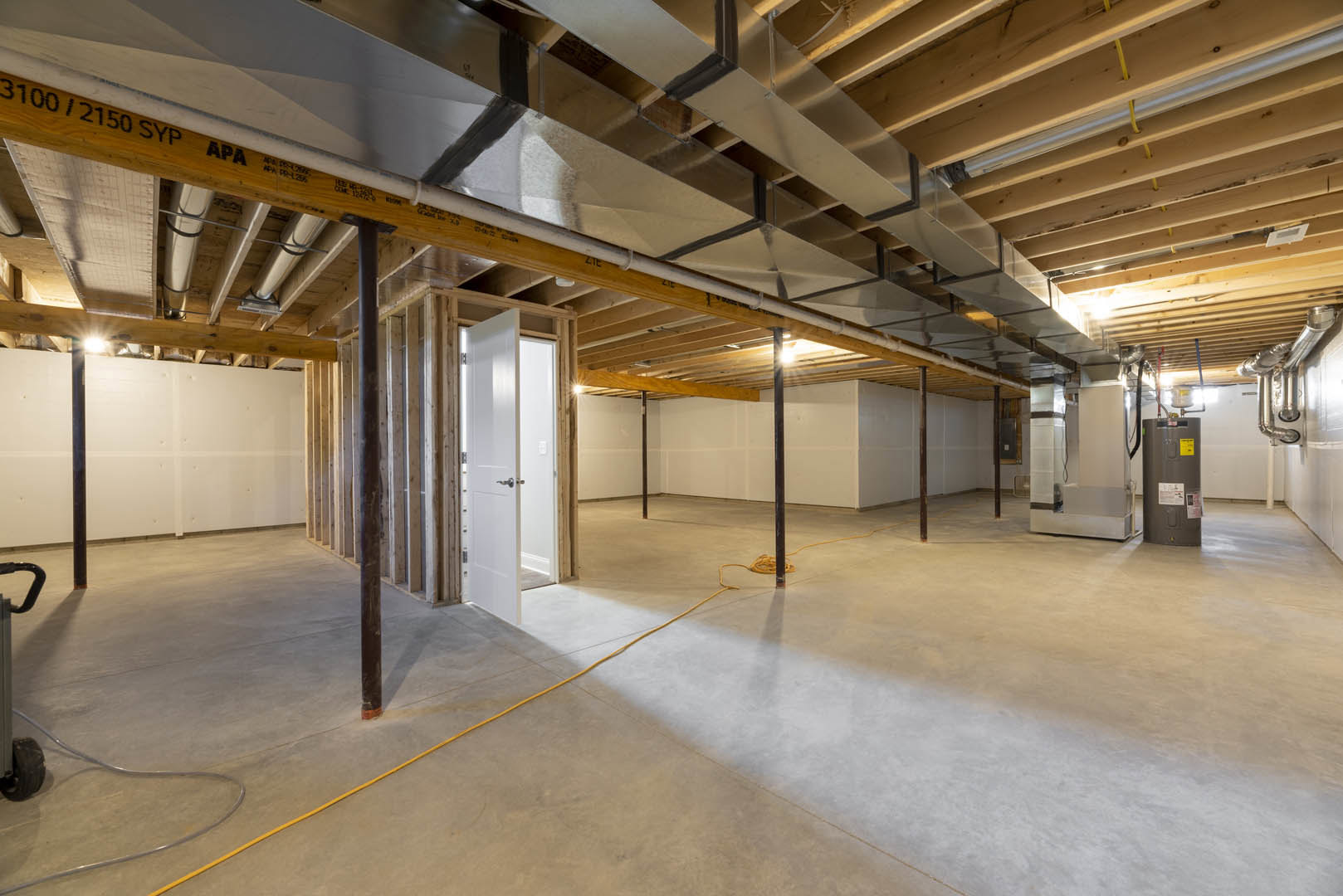 Modern interior room featuring a white ceiling with exposed metal beam and pipes, white door with silver handle, yellow rope on light-colored floor, and smooth white wall surfaces.