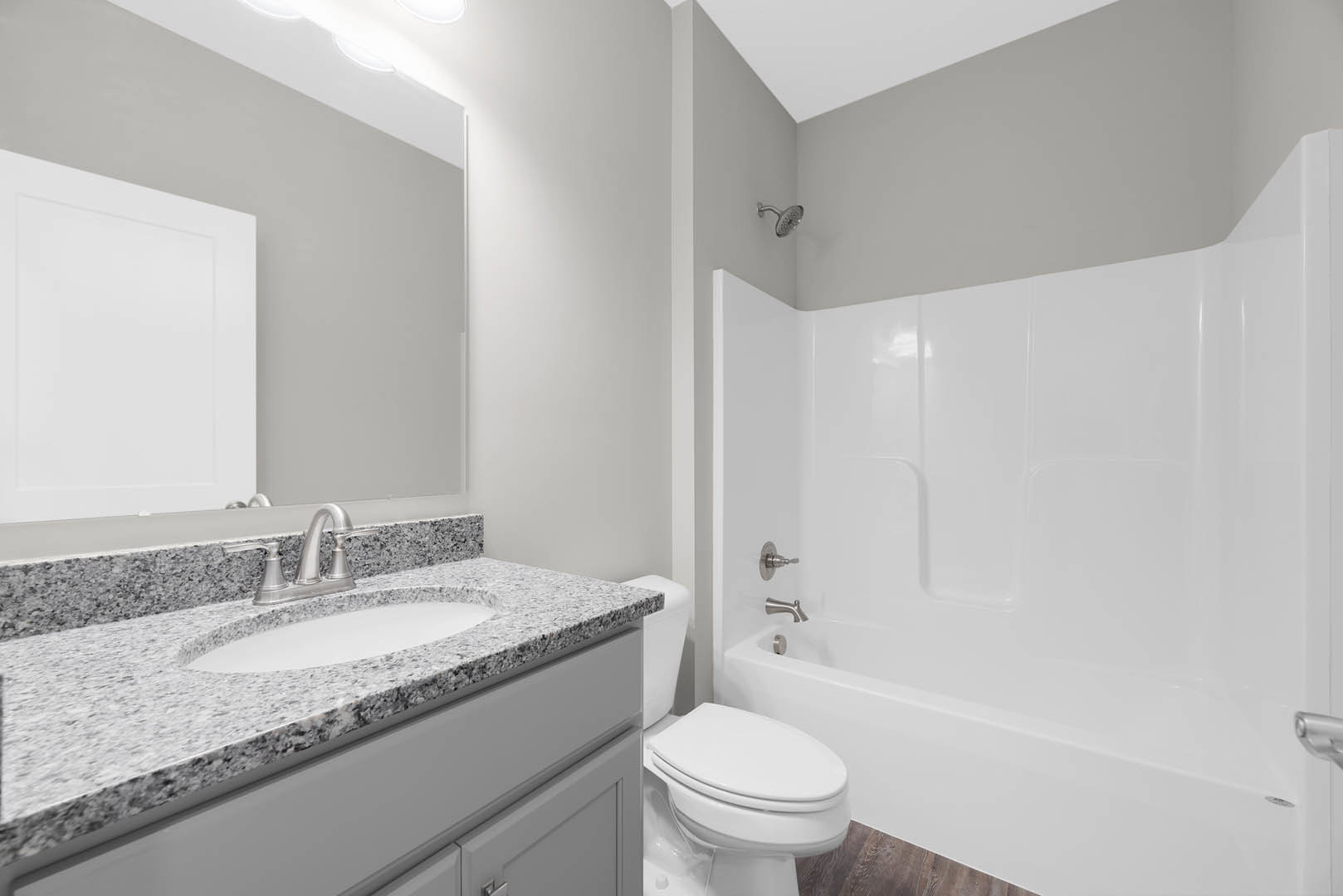 Modern bathroom featuring a freestanding white bathtub, wall-mounted sink with stone countertop, chrome faucet, tiled walls, and glass shower enclosure.