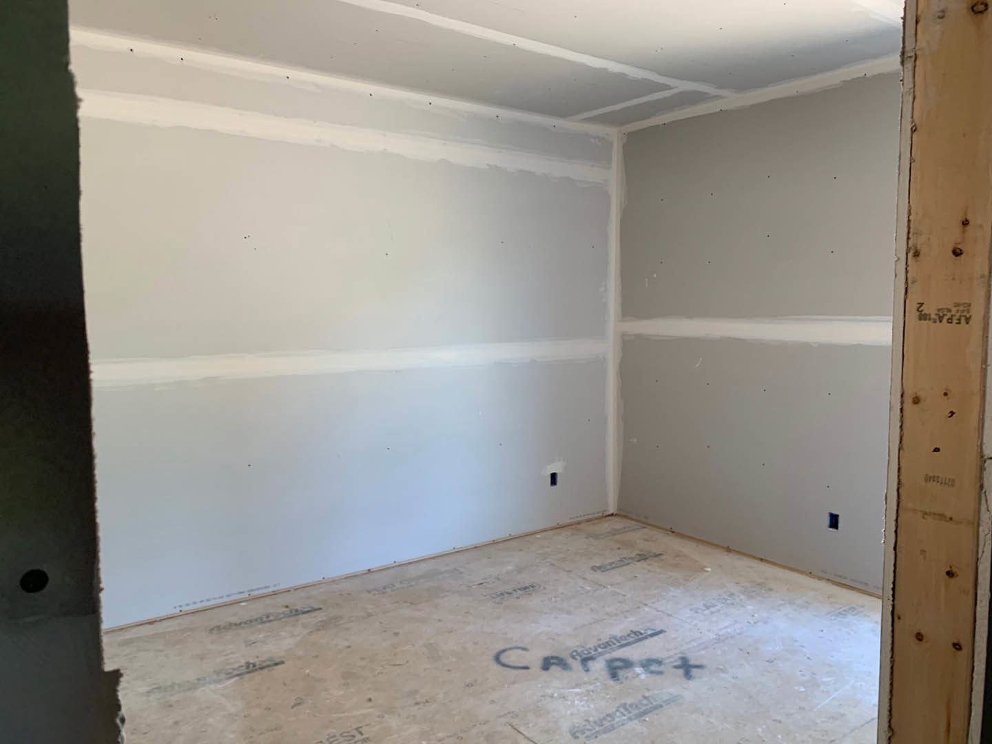 Bright room with smooth white walls, white trim, and light-colored carpet flooring