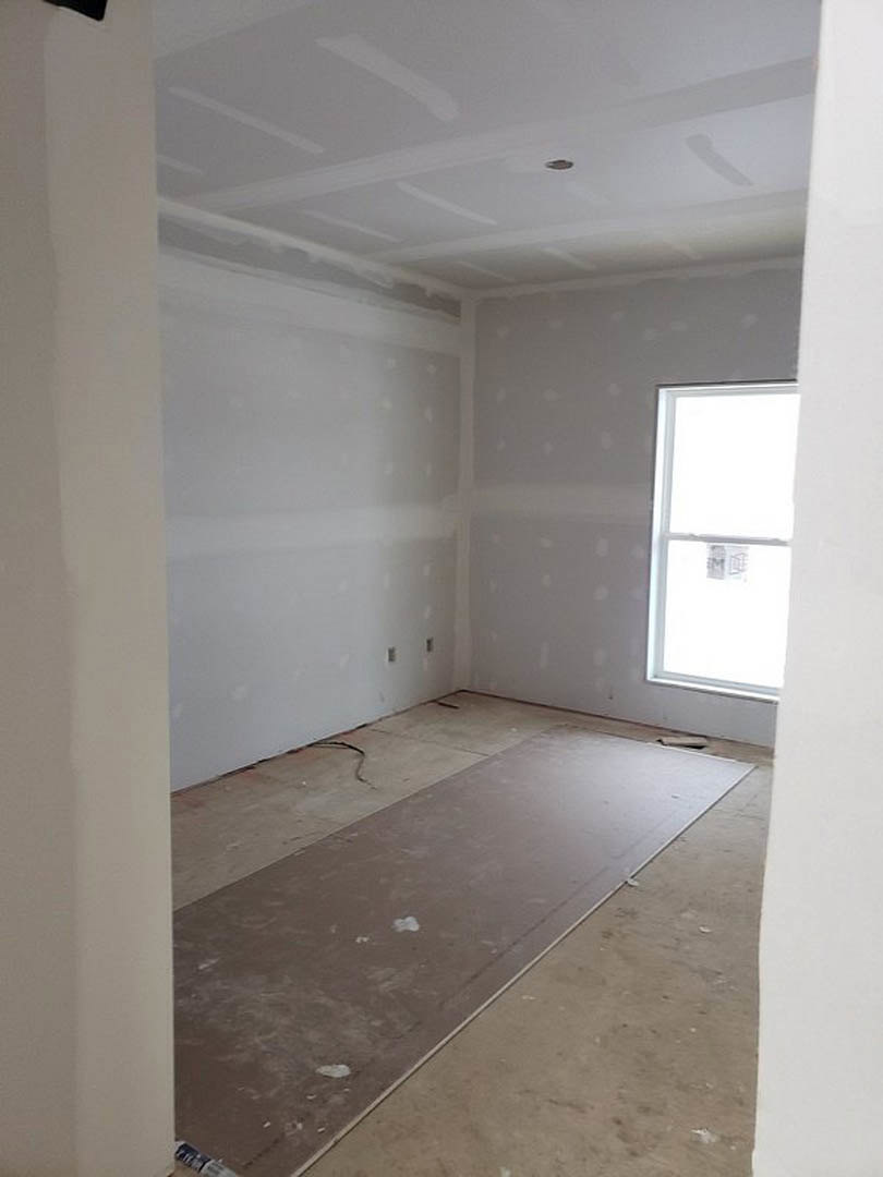 Bright room with white walls, white-framed window, plush carpet flooring, wood trim, and smooth white ceiling with recessed lighting