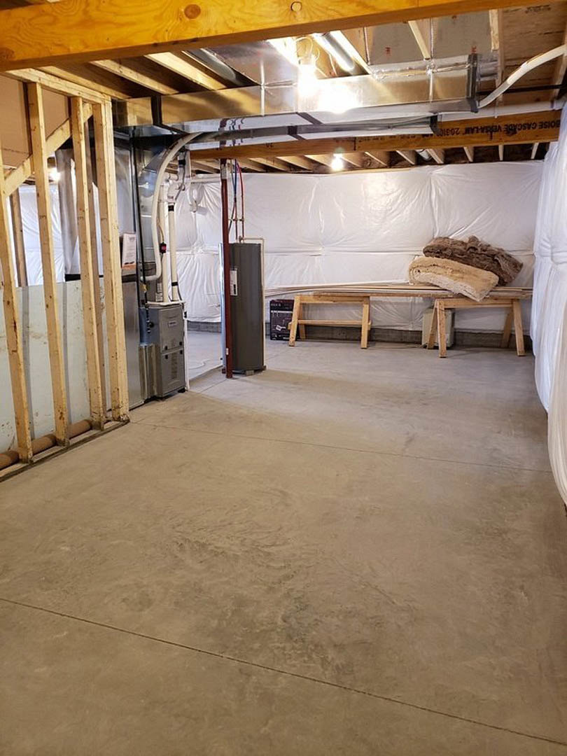 Wood bench against smooth white plaster wall, concrete floor, exposed ceiling beam, minimal furnishings
