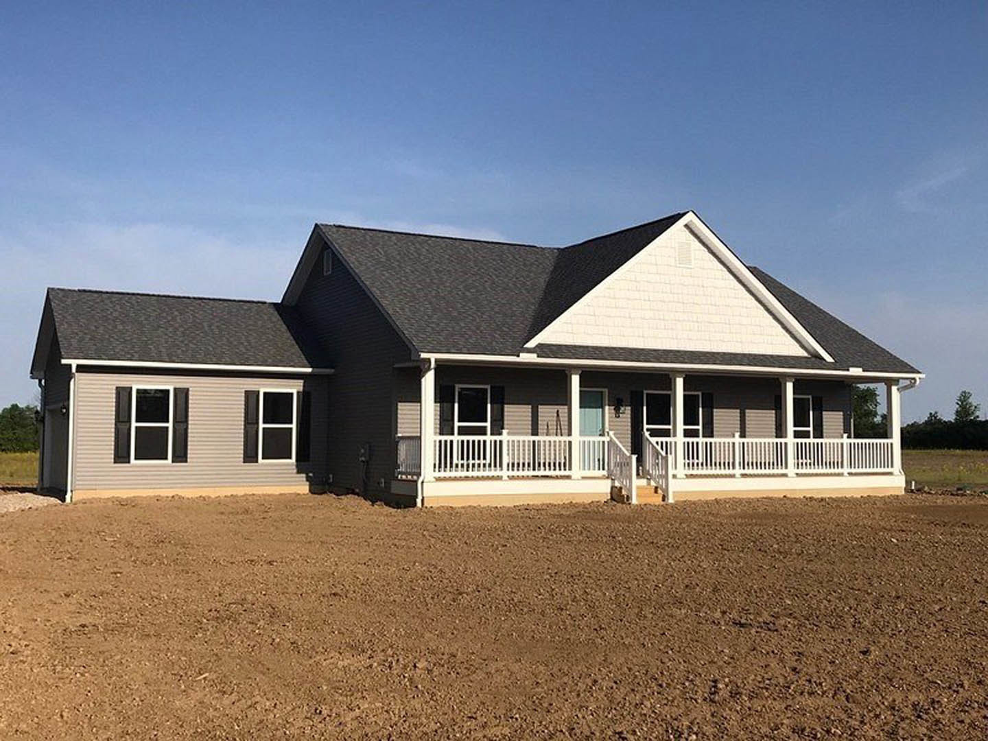 Two-story house with white porch railing, black shuttered windows, and white-framed windows overlooking a dirt field bordered by a white fence, Southfork Ranch visible in the