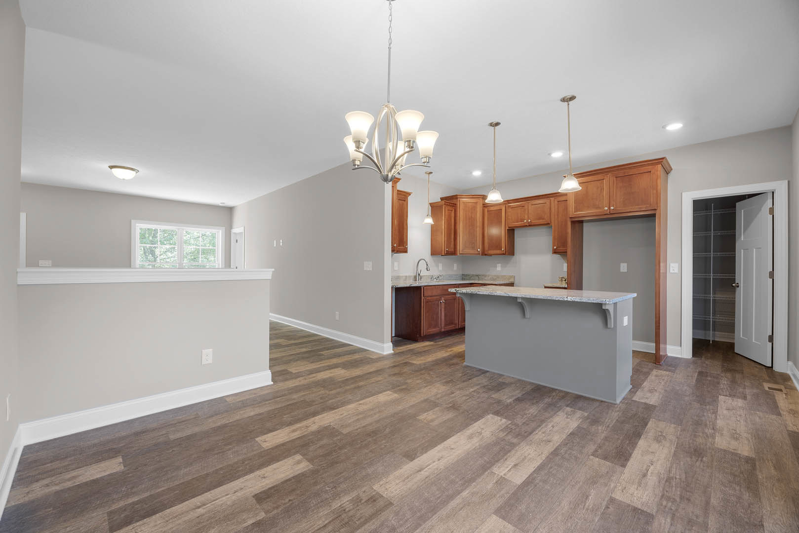 Open kitchen and dining area featuring hardwood floors, marble countertop, white cabinetry with open shelving, multiple-pane windows, and a close-up view of a door.