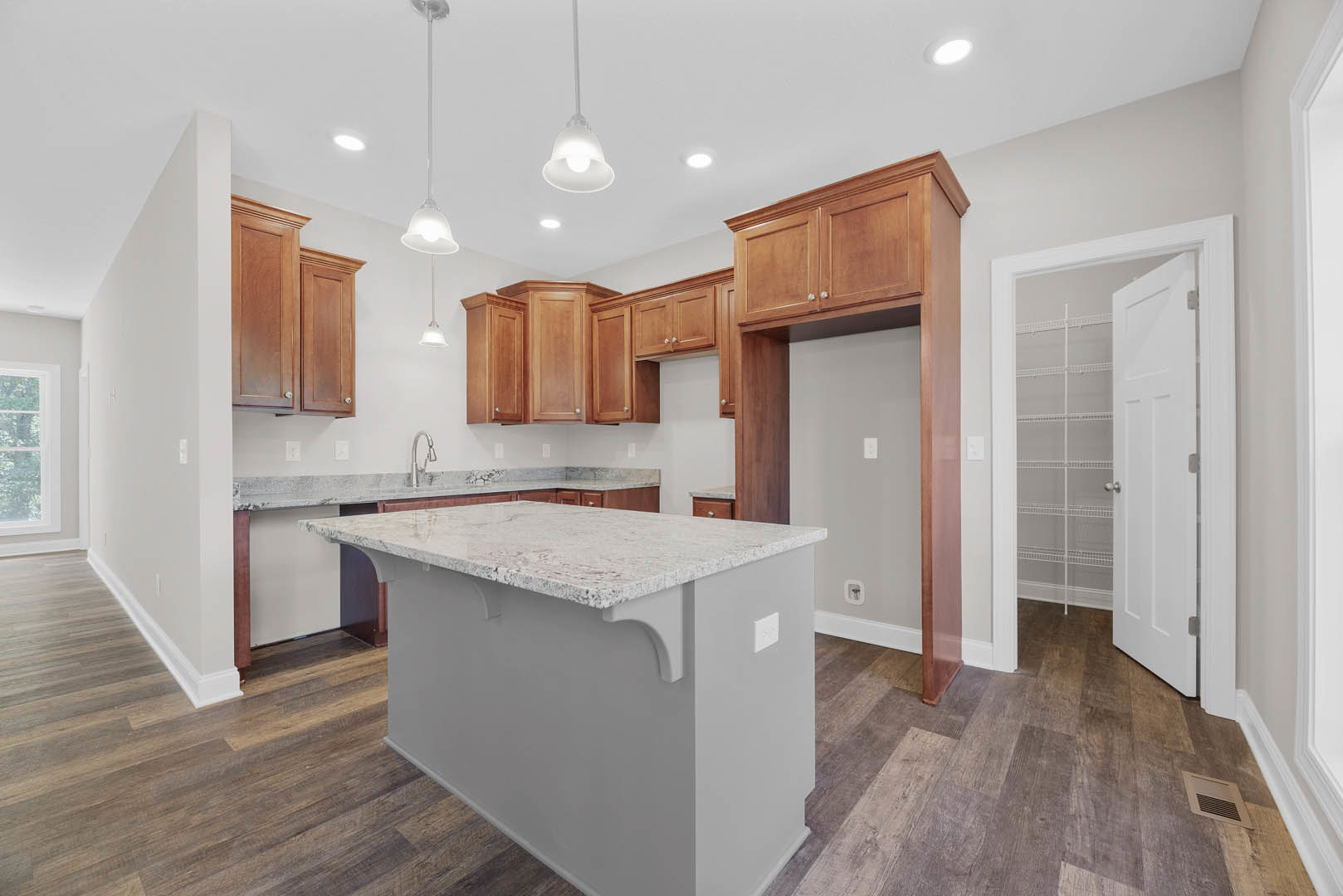 Marble kitchen island with waterfall edge, white cabinetry, tile backsplash, built-in sink, pendant light with black accent, open shelving, and light wood flooring