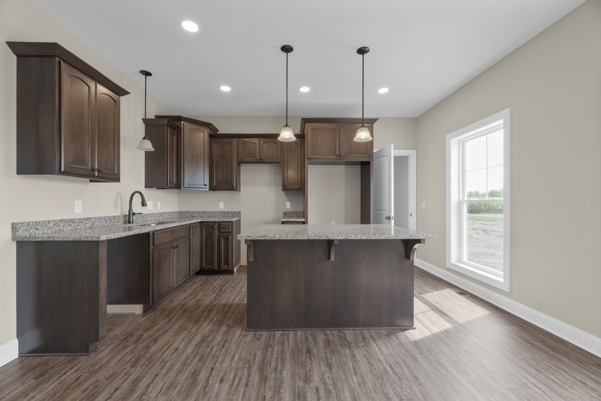 Granite countertops with wood shelving, stainless steel faucet, tile backsplash, cabinetry, large window overlooking a field, pendant light fixture, and light-colored flooring