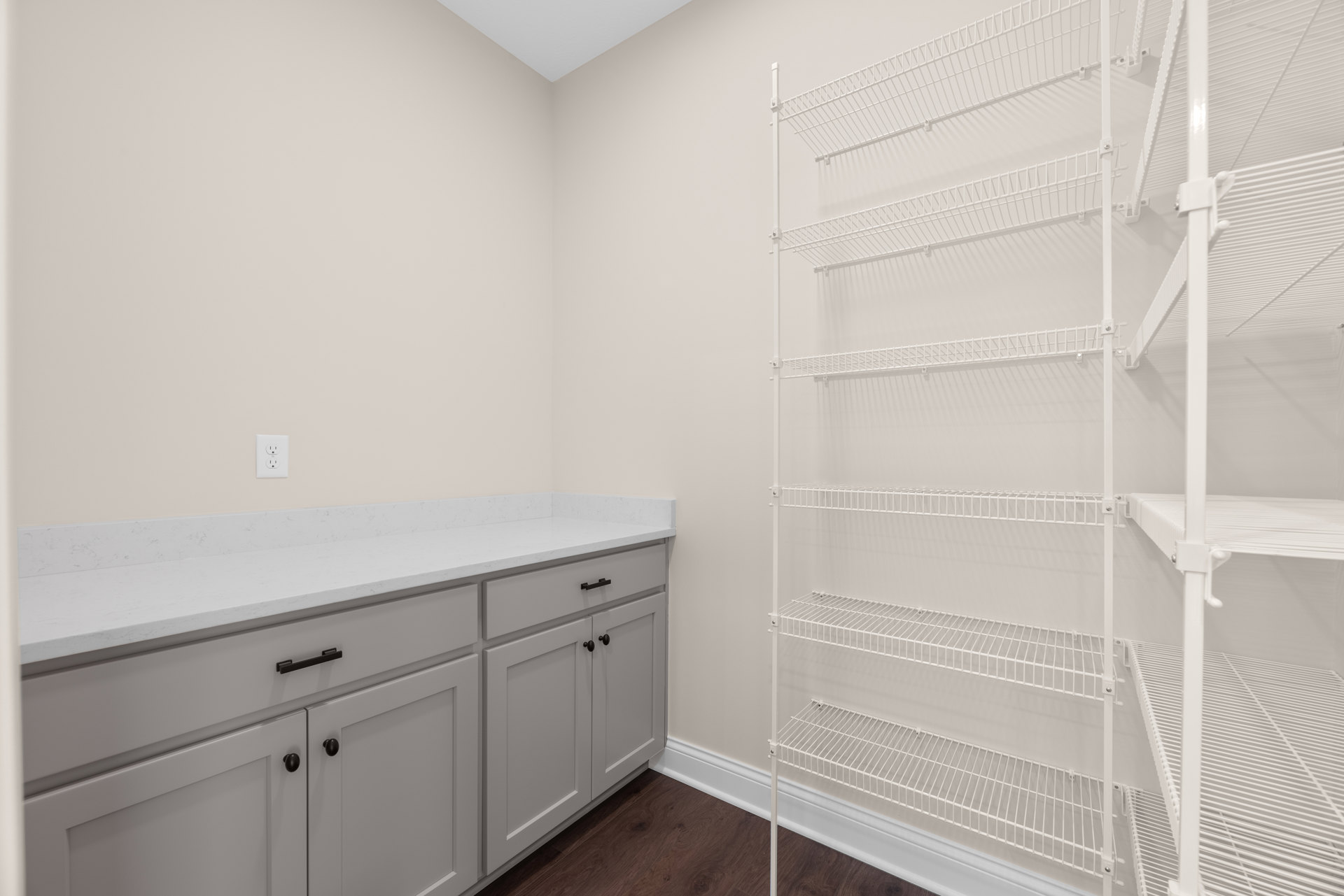White cabinetry with black handles, white wire shelving mounted on wall, white countertop, and close-up views of door and cabinet in a kitchen interior.