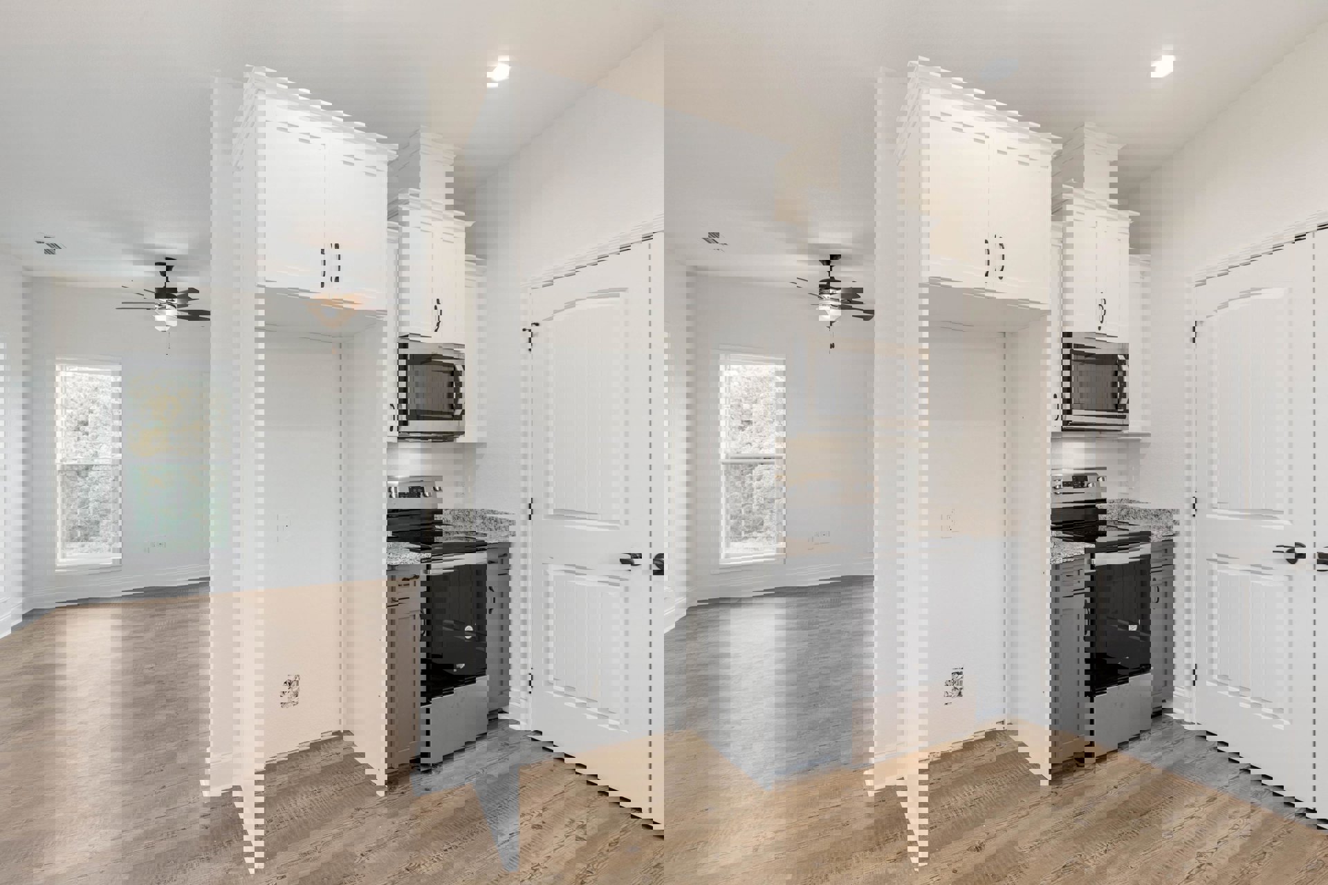 White shaker cabinets, black freestanding stove, stainless microwave, quartz countertops, window overlooking trees, recessed ceiling light