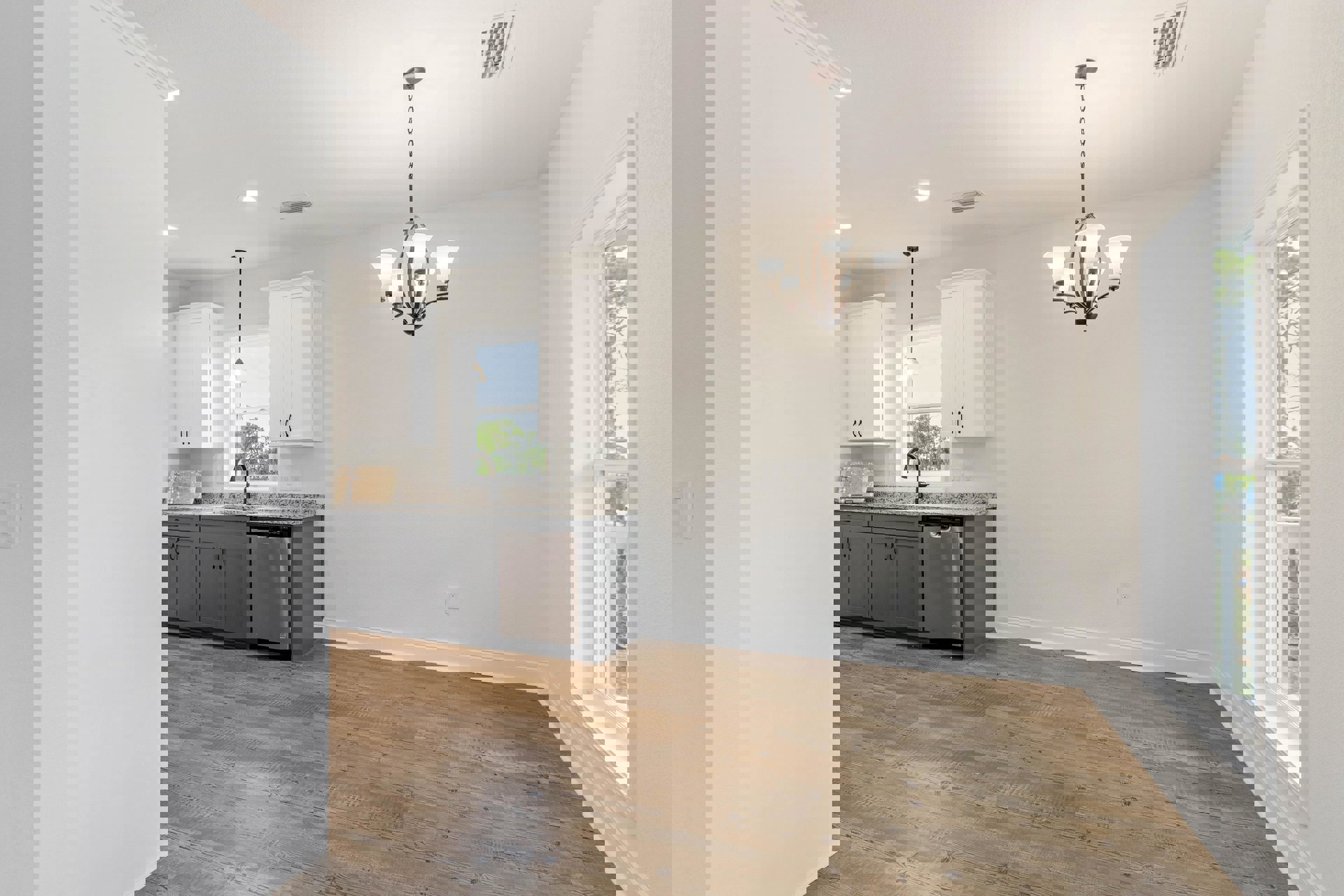 Kitchen with wood flooring, white cabinetry, chandelier, large window, and stainless steel faucet over a sink