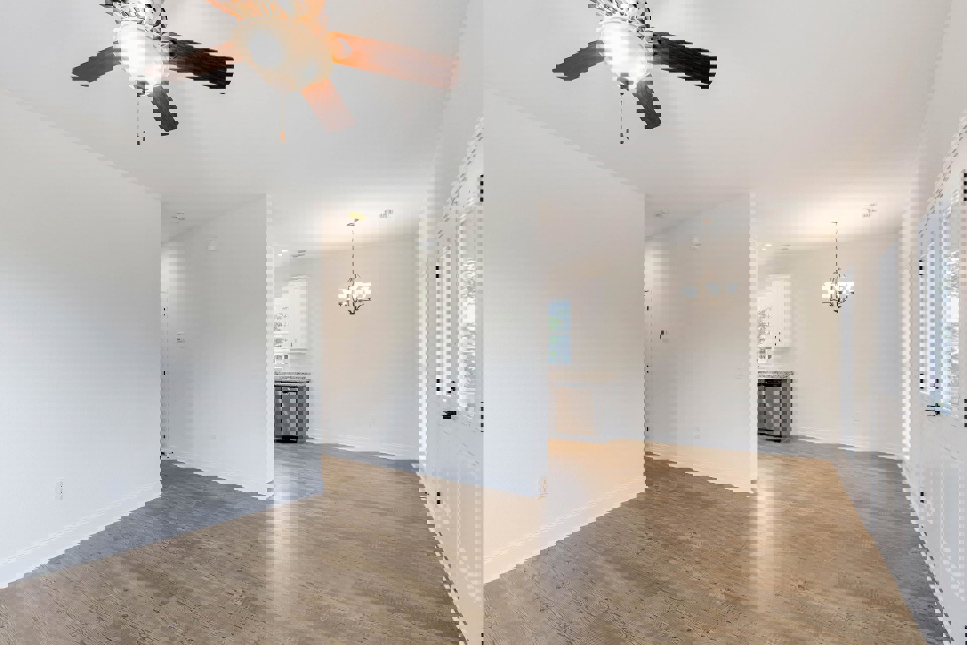 Open kitchen with stainless steel refrigerator and dishwasher, wood laminate flooring, white plaster walls, ceiling fan with light fixture, and modern chandelier.