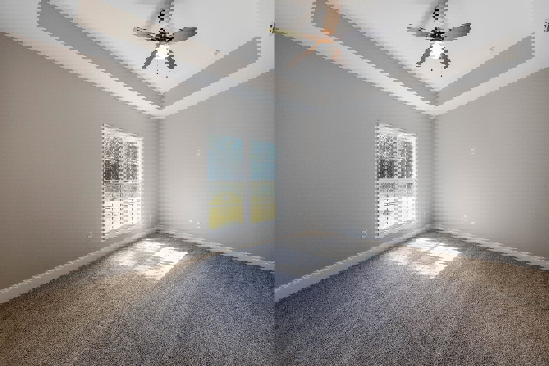 Carpeted room with white walls, ceiling fan with light fixture, large window overlooking fenced grassy field, crown molding along ceiling.